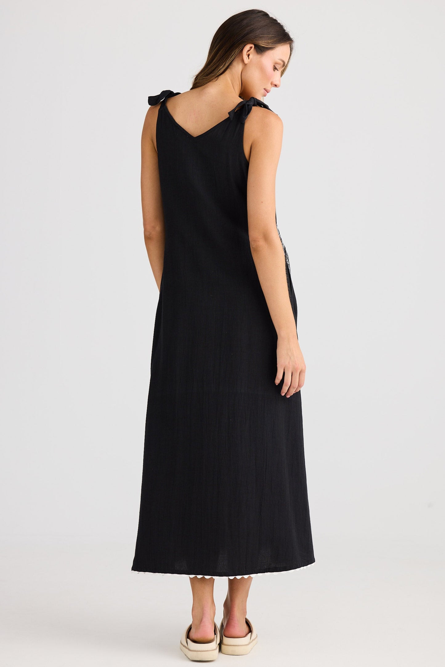 Woman wearing a black sleeveless dress on a white background