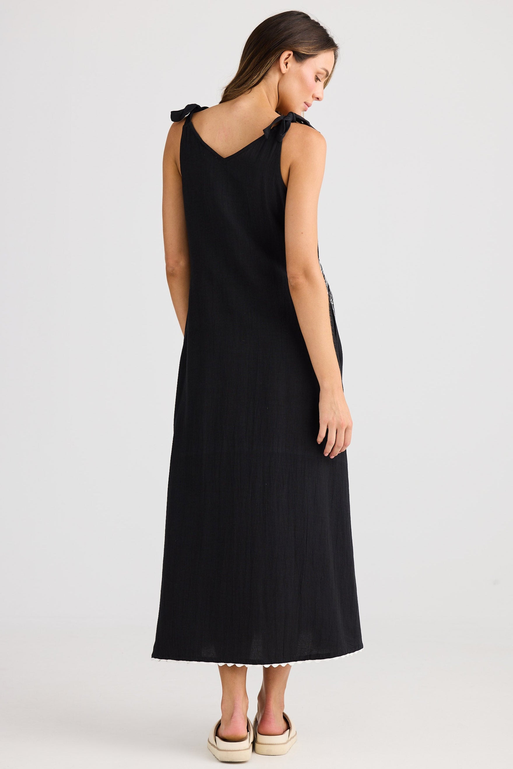 Woman wearing a black sleeveless dress on a white background