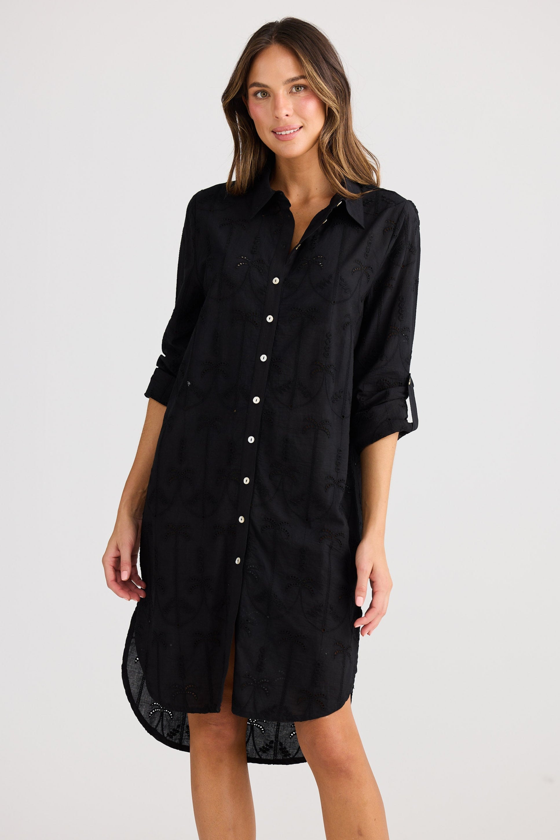 Woman wearing a black shirt dress on a white background