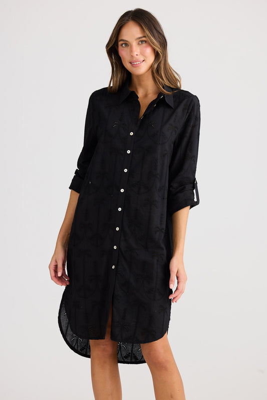 Woman wearing a black shirt dress on a white background