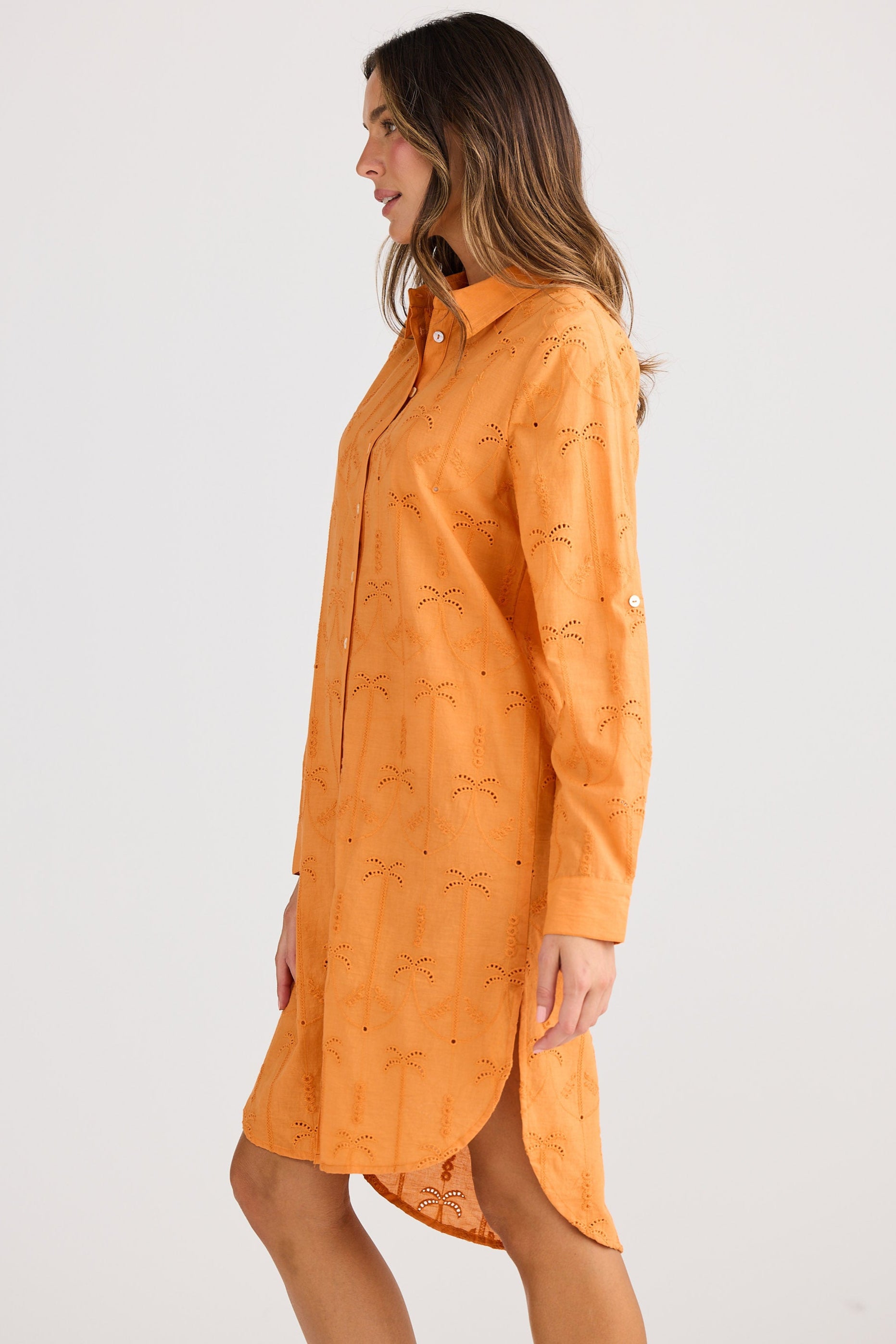 Woman wearing an orange dress with a subtle pattern on a white background