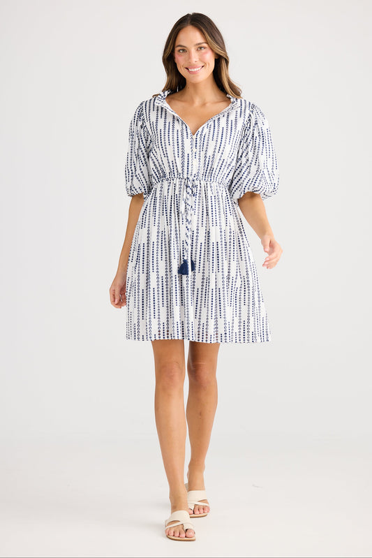 Woman wearing a blue and white patterned dress on a white background