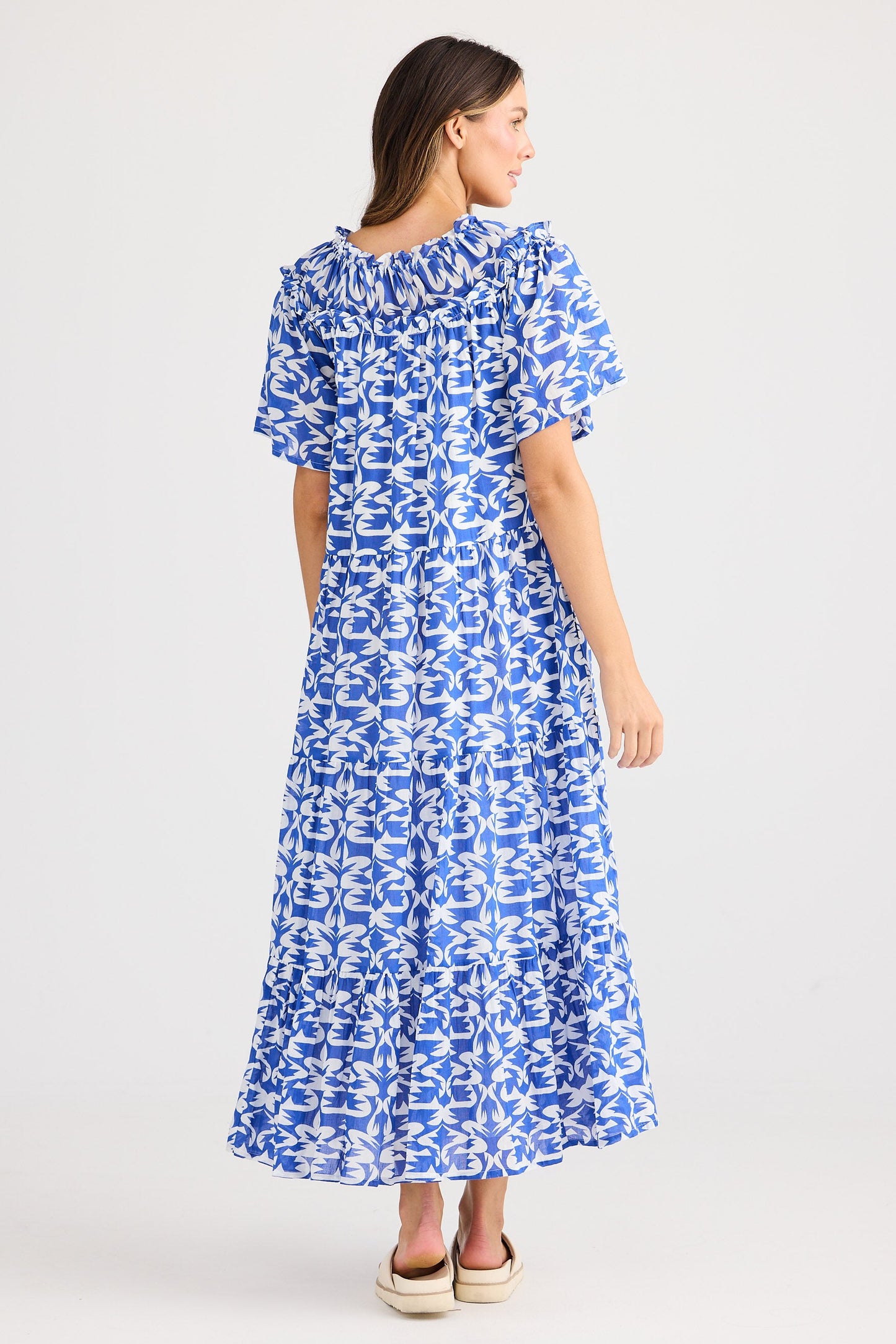 Woman wearing a blue patterned dress on a white background