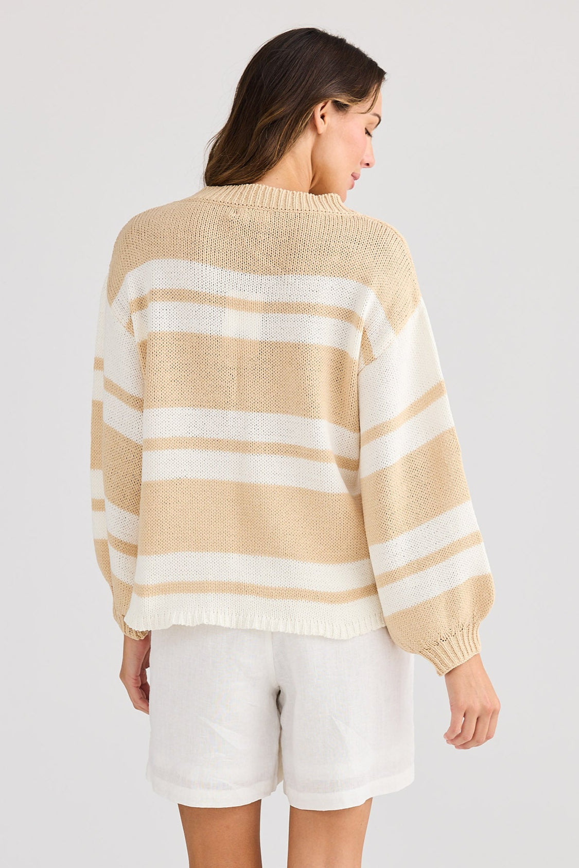 Woman wearing a striped sweater and shorts on a white background