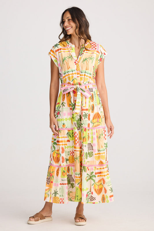 Woman wearing a colorful dress with a pineapple pattern on a white background