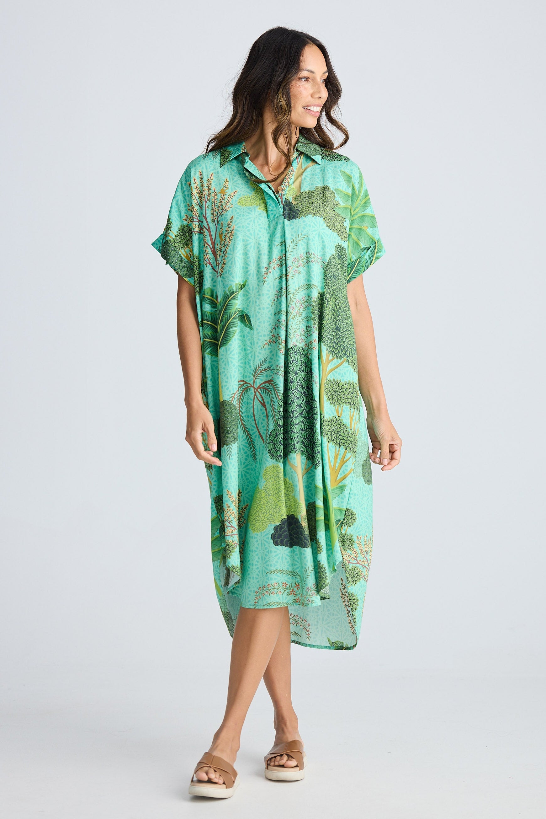 Woman wearing a green floral dress on a white background