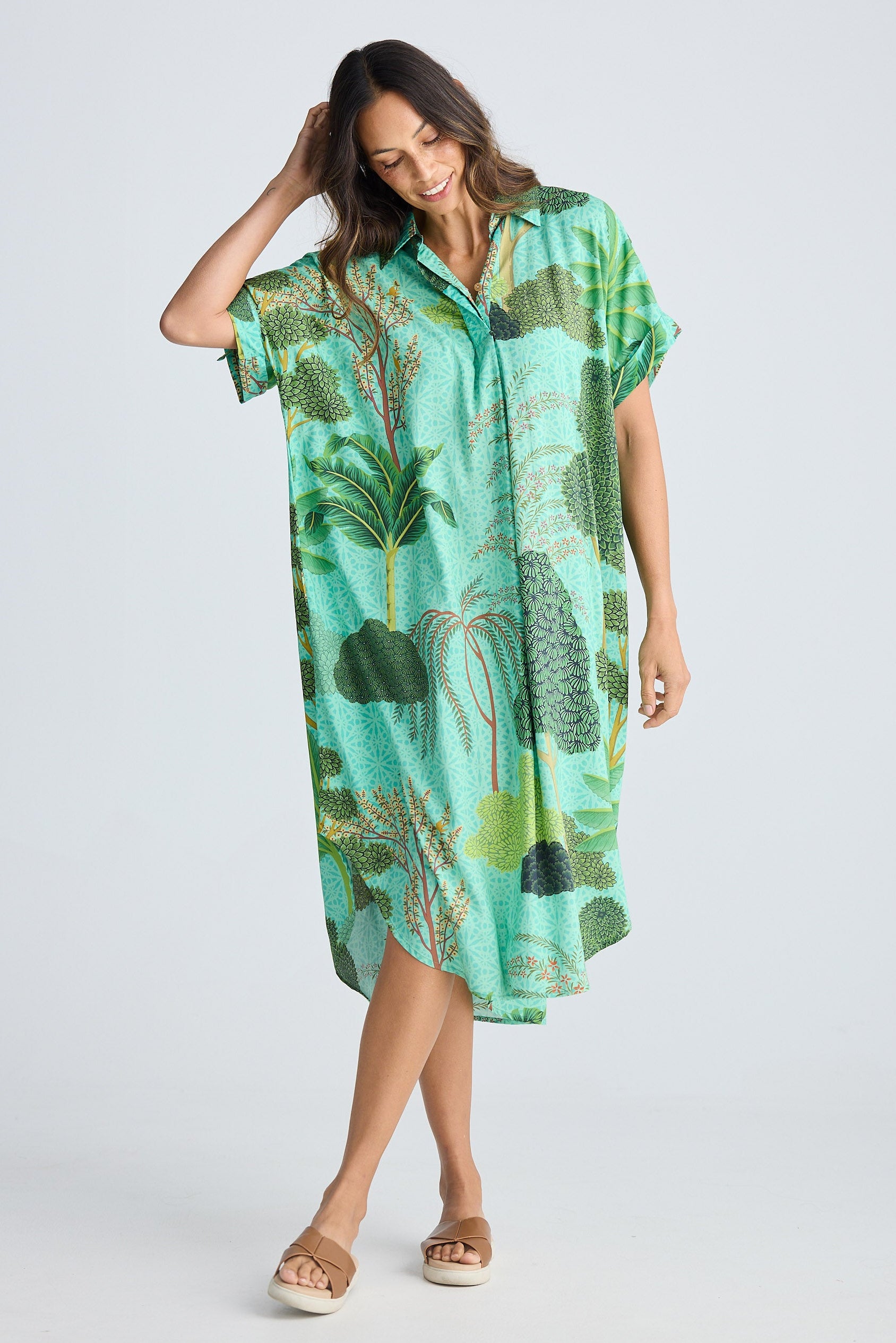 Woman wearing a green patterned dress on a white background
