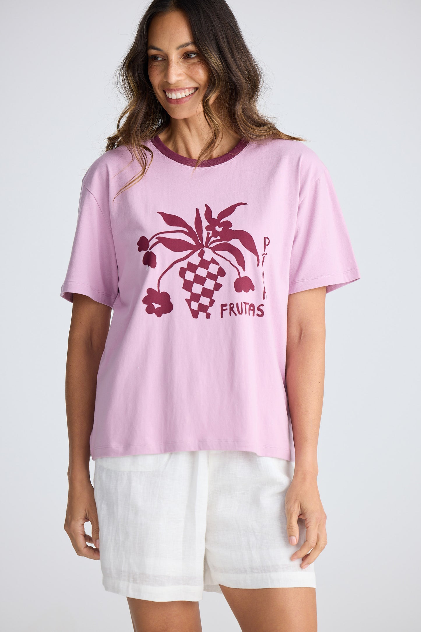 Woman wearing a pink t-shirt with a graphic design on a white background