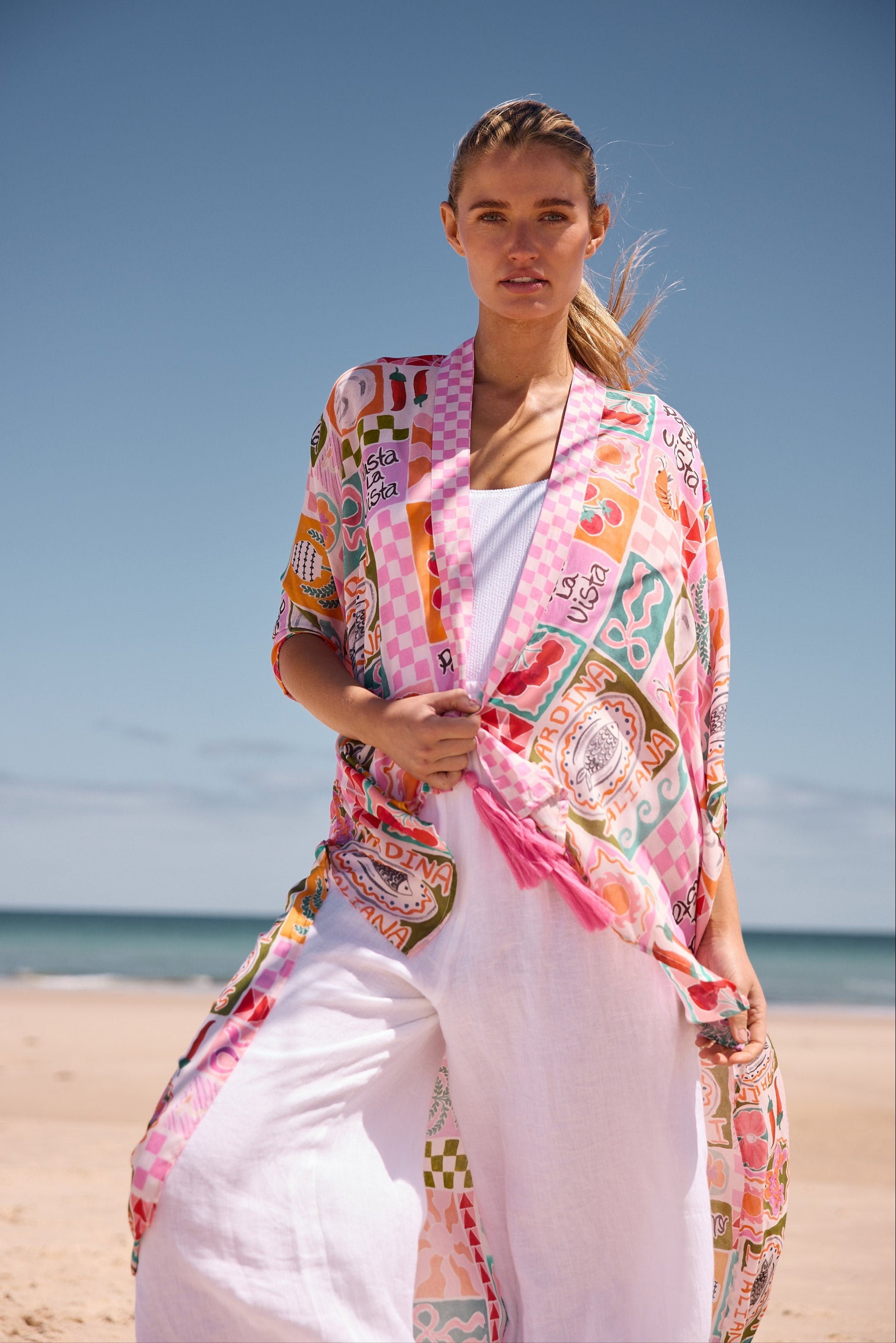 Woman wearing a colorful kimono-style garment on a beach