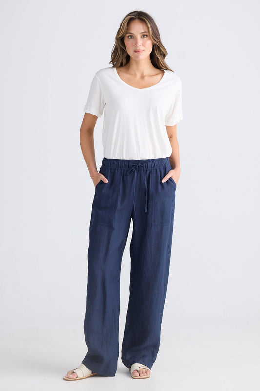 Woman wearing a white top and blue pants on a white background