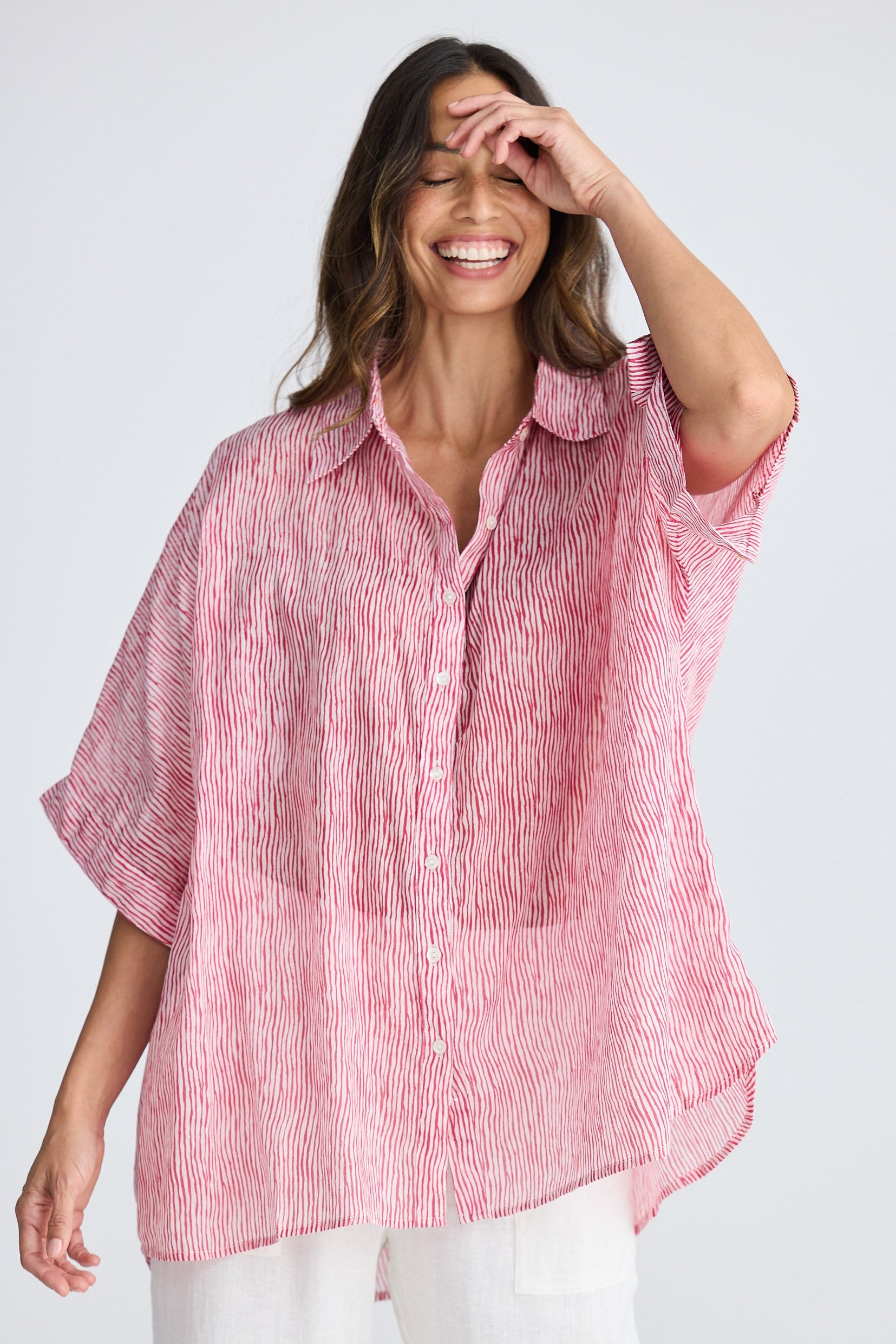 Woman wearing a pink striped shirt against a white background