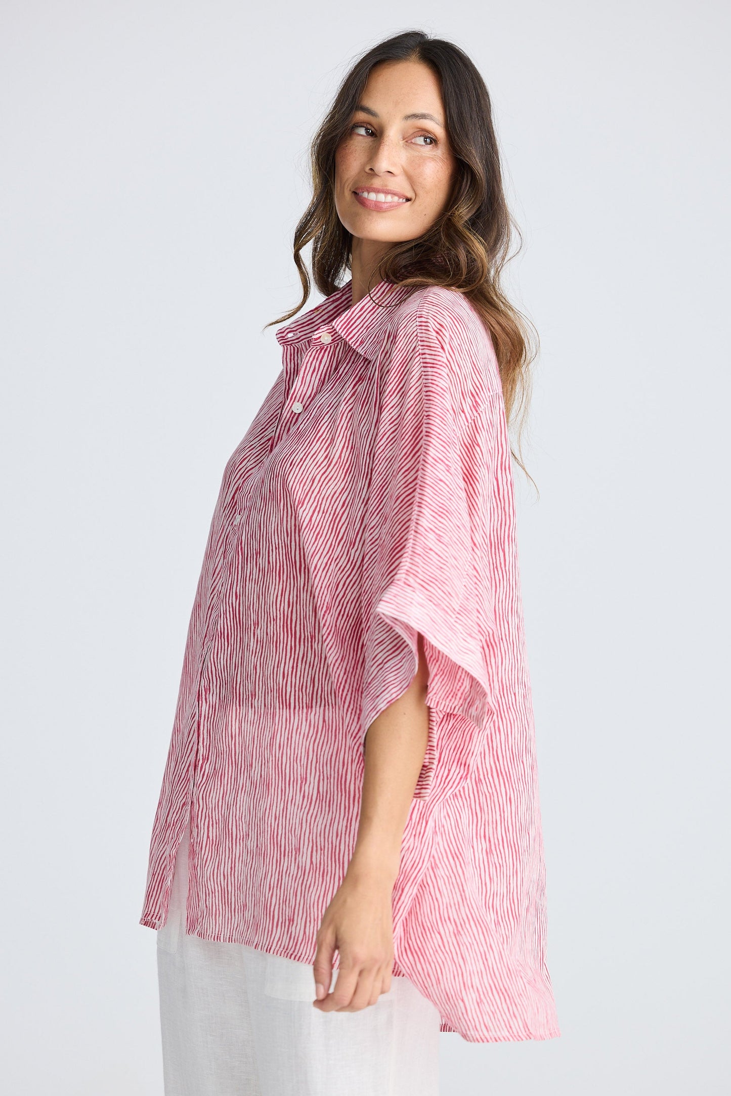 Woman wearing a pink and white striped shirt on a white background