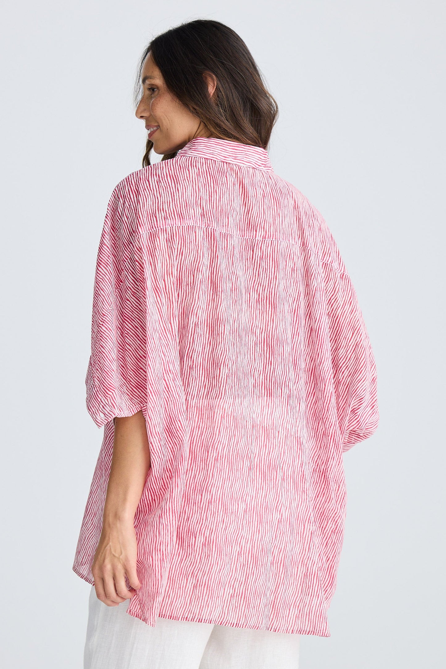 Woman wearing a pink striped shirt on a white background
