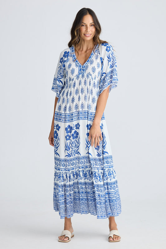 Woman wearing a blue and white patterned dress on a white background