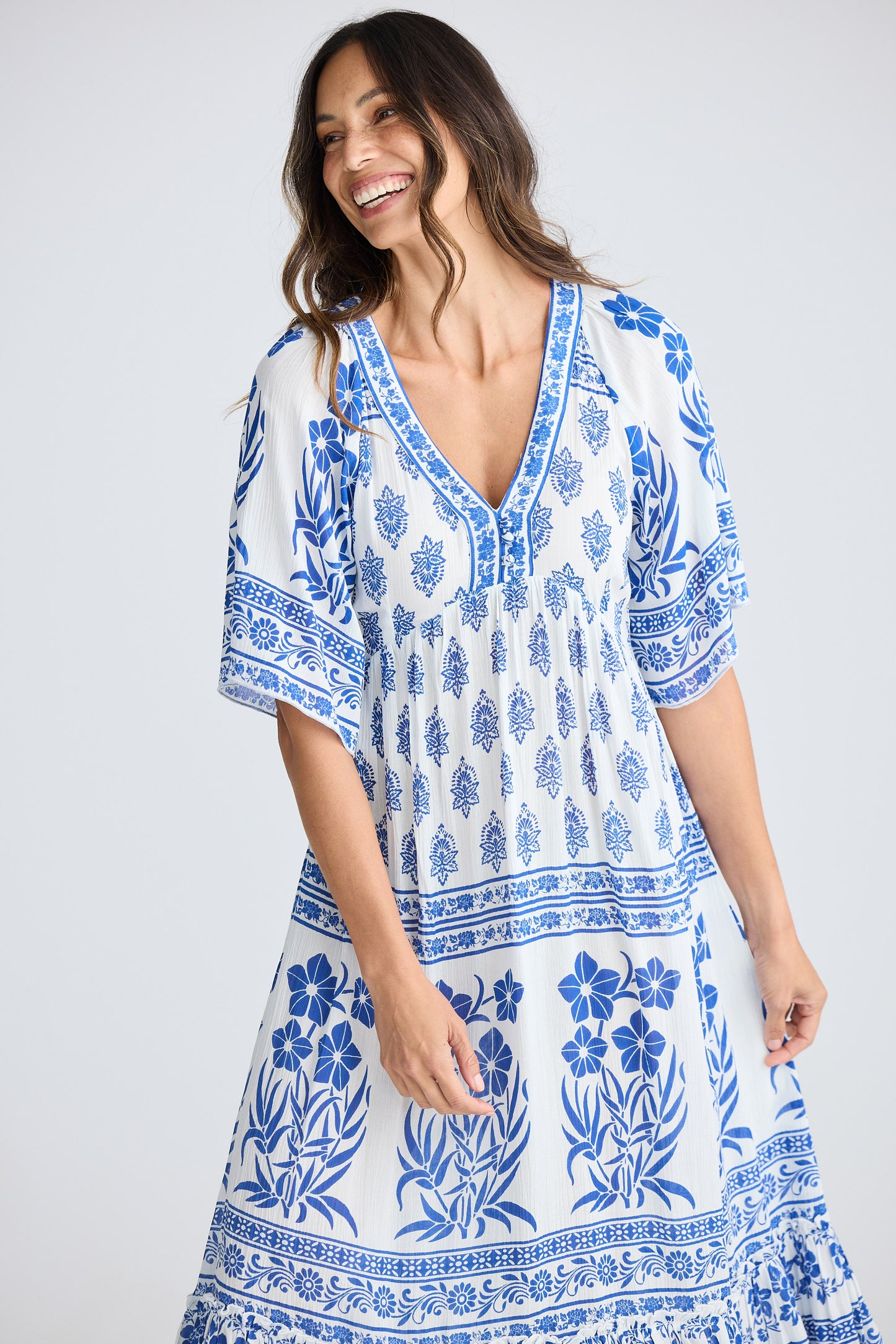 Woman wearing a blue and white patterned dress on a plain background