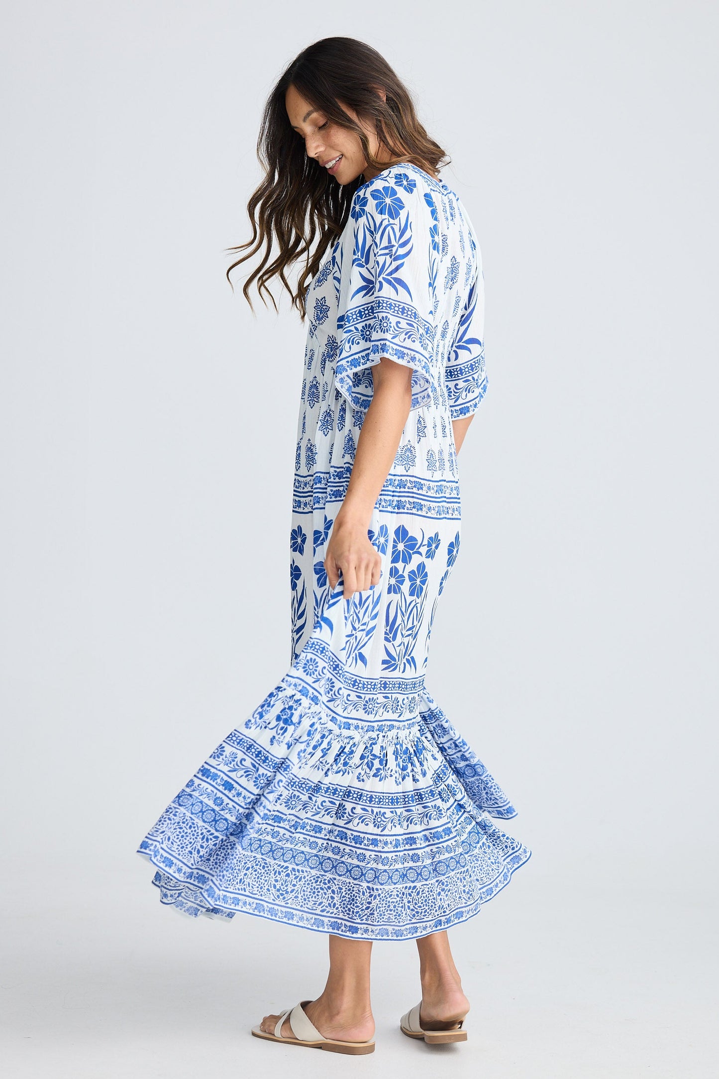 Woman wearing a blue and white patterned dress on a white background