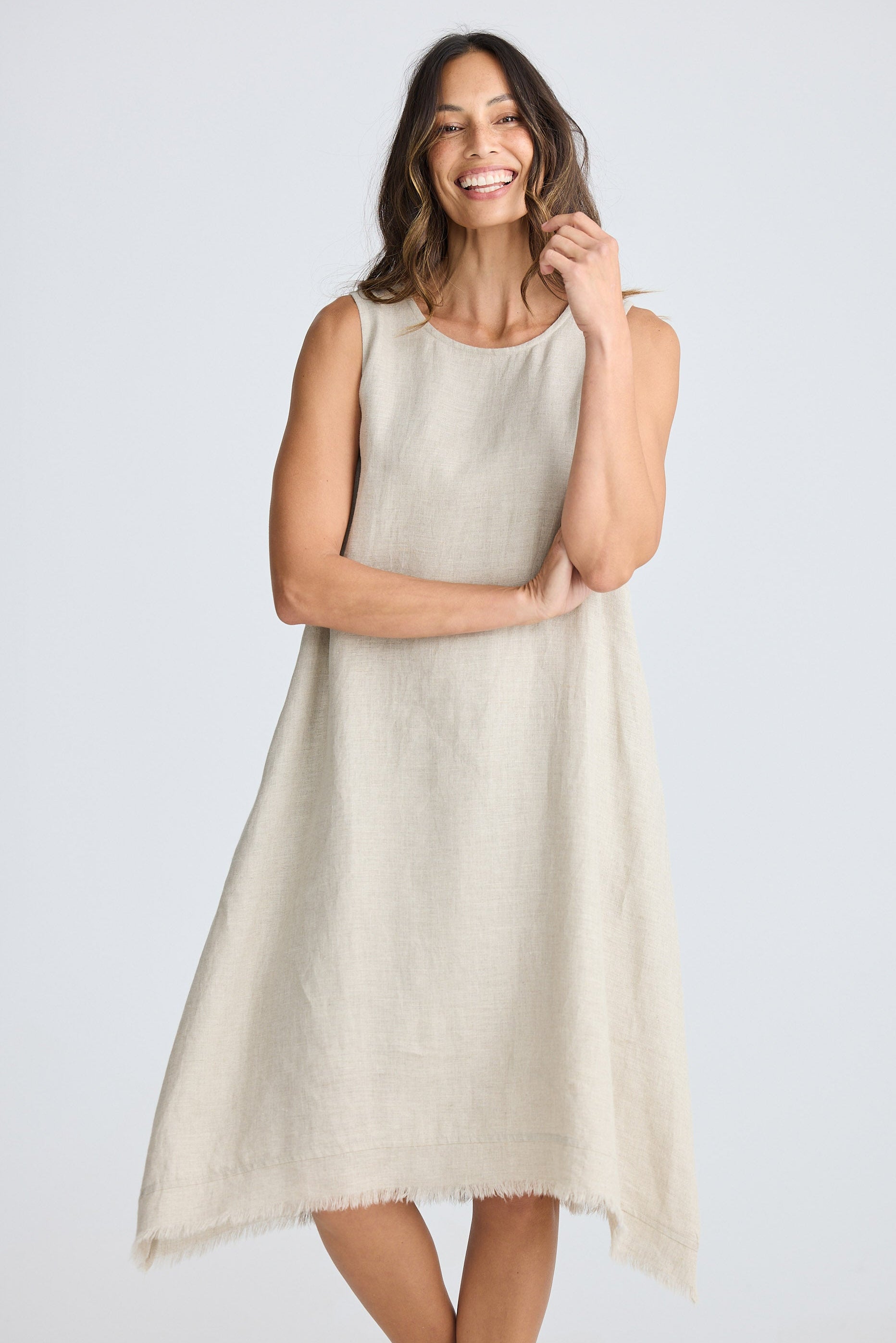 Woman wearing a beige sleeveless dress on a white background