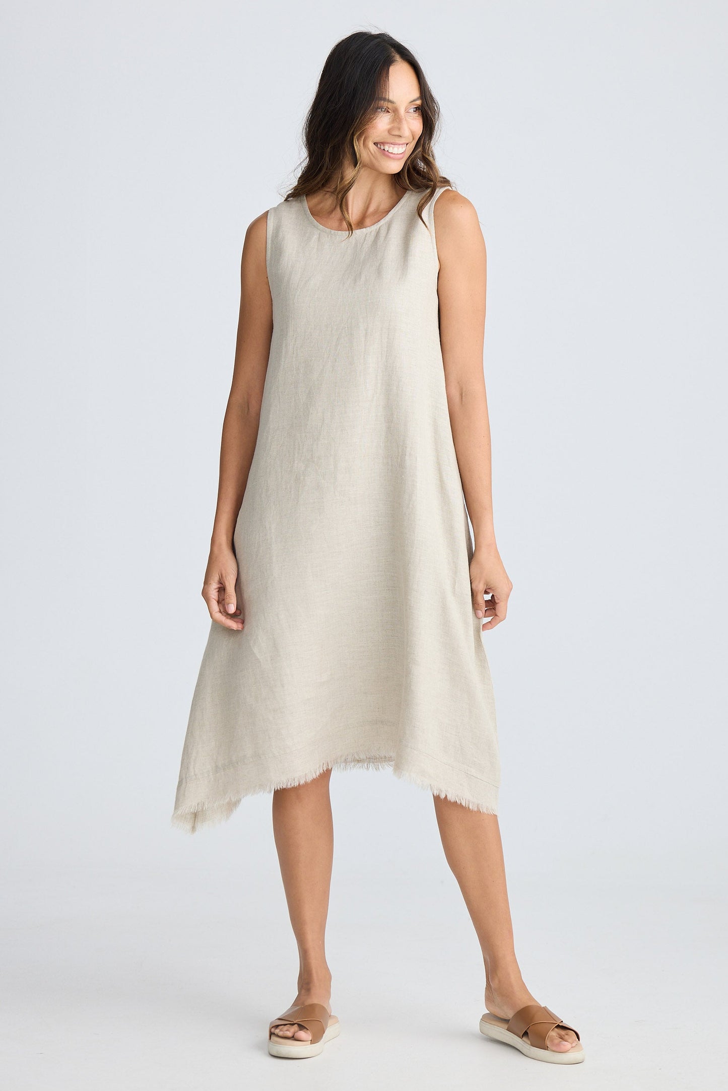Woman wearing a beige sleeveless dress on a white background