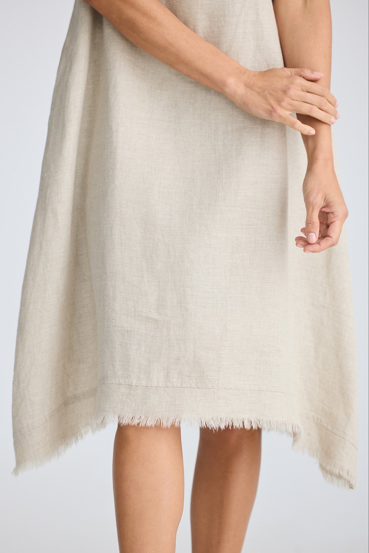 Beige dress with fringe detail on a plain background