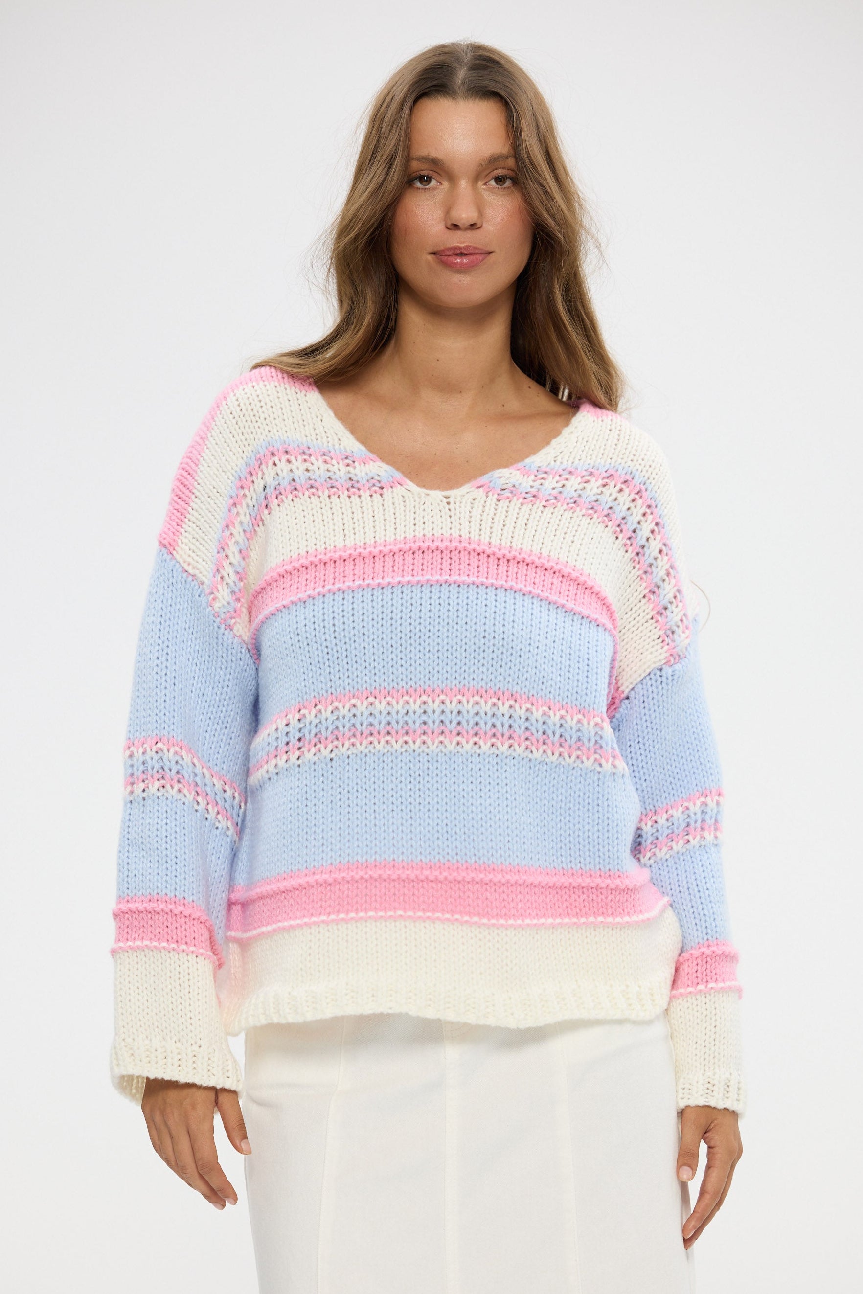 Woman wearing a colorful striped sweater against a white background