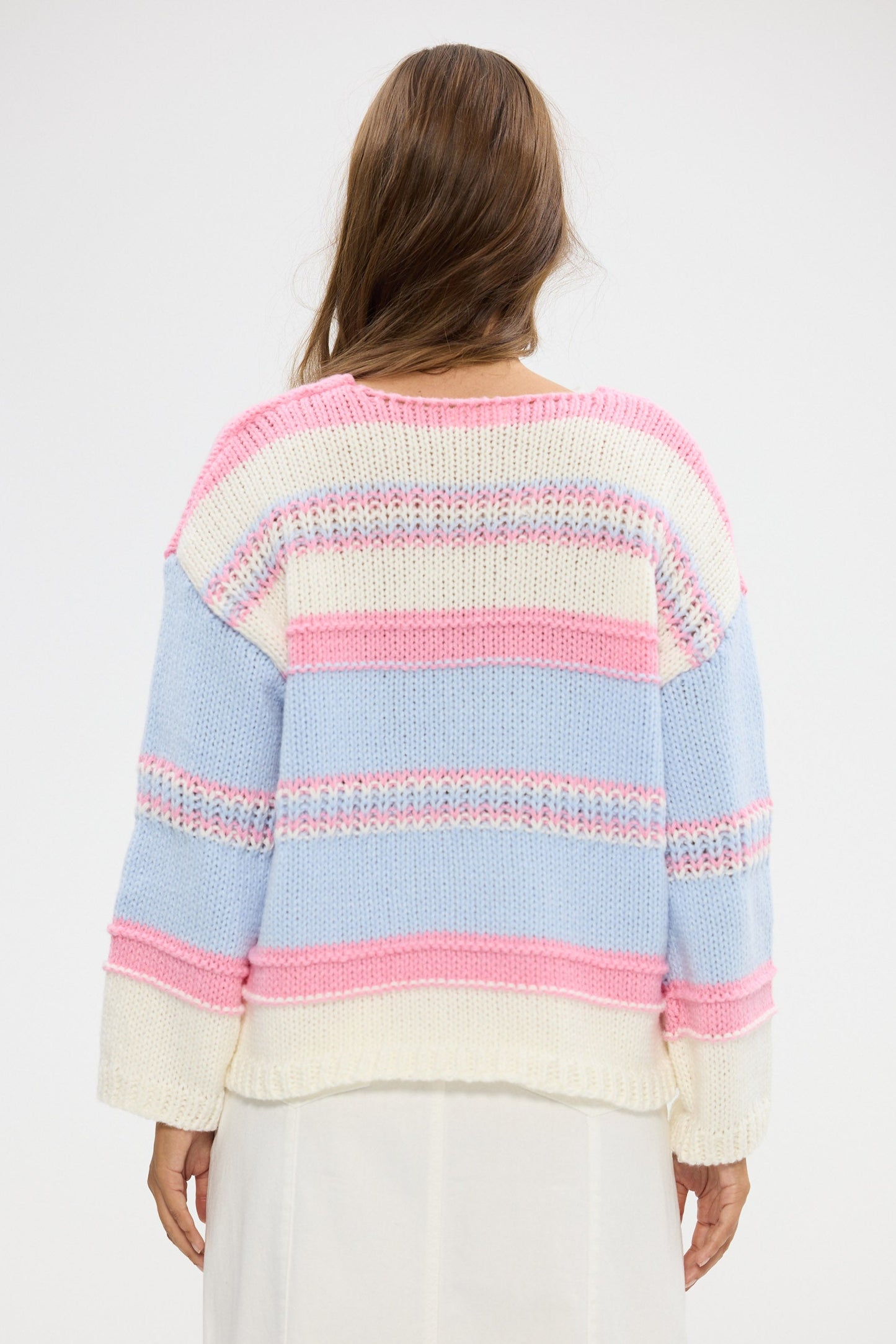 Woman wearing a colorful striped sweater on a white background
