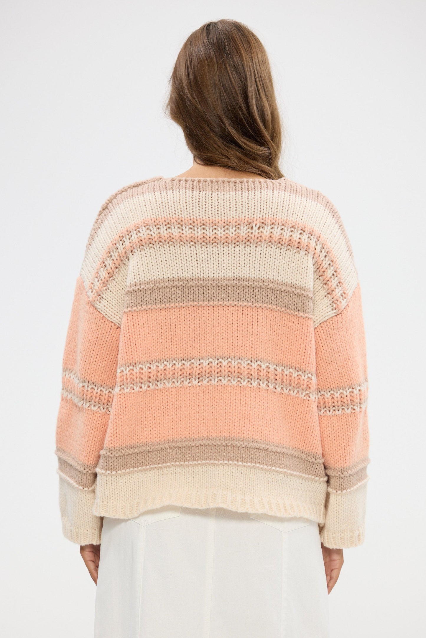 Woman wearing a striped sweater with a white background