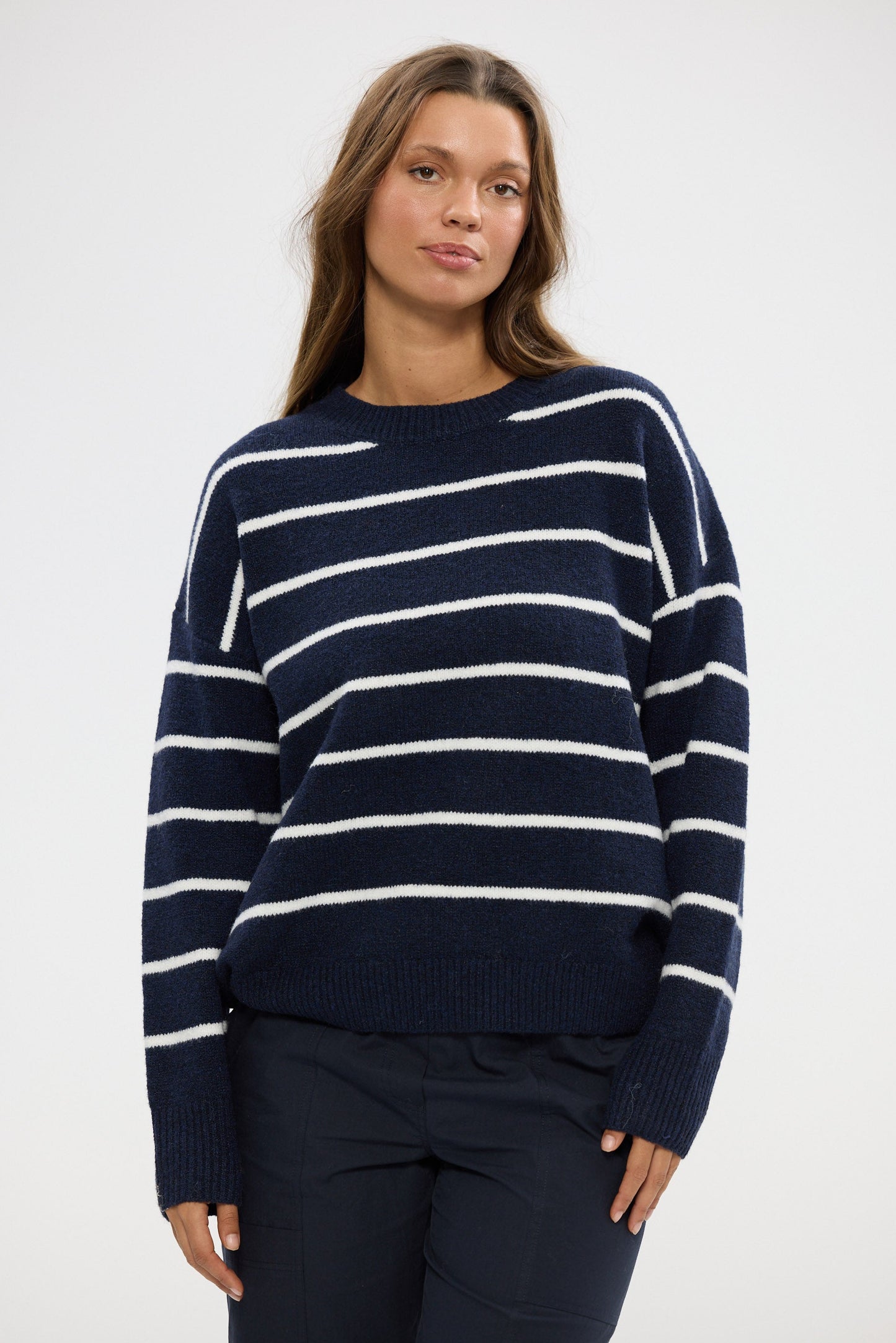 Woman wearing a navy and white striped sweater on a white background