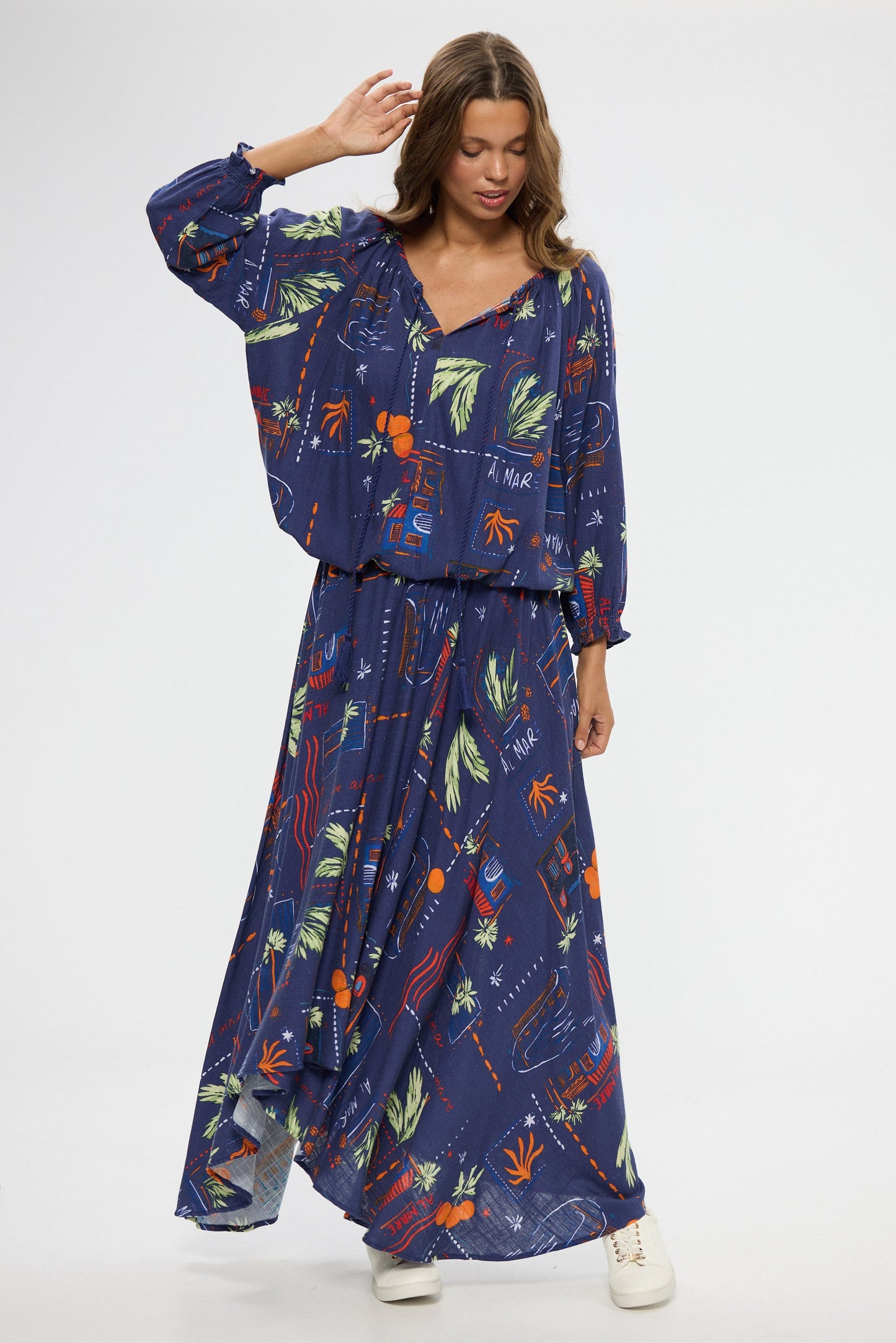 Woman wearing a blue floral top and skirt on a white background