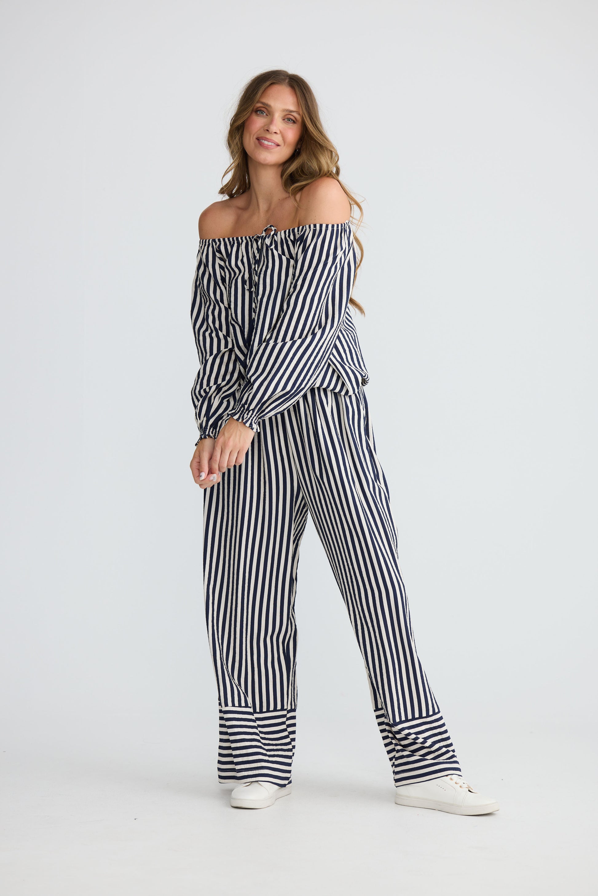 Model wearing Seaside Top Navy and White Stripe with neck ties and shirred cuffs, alternate view on white background