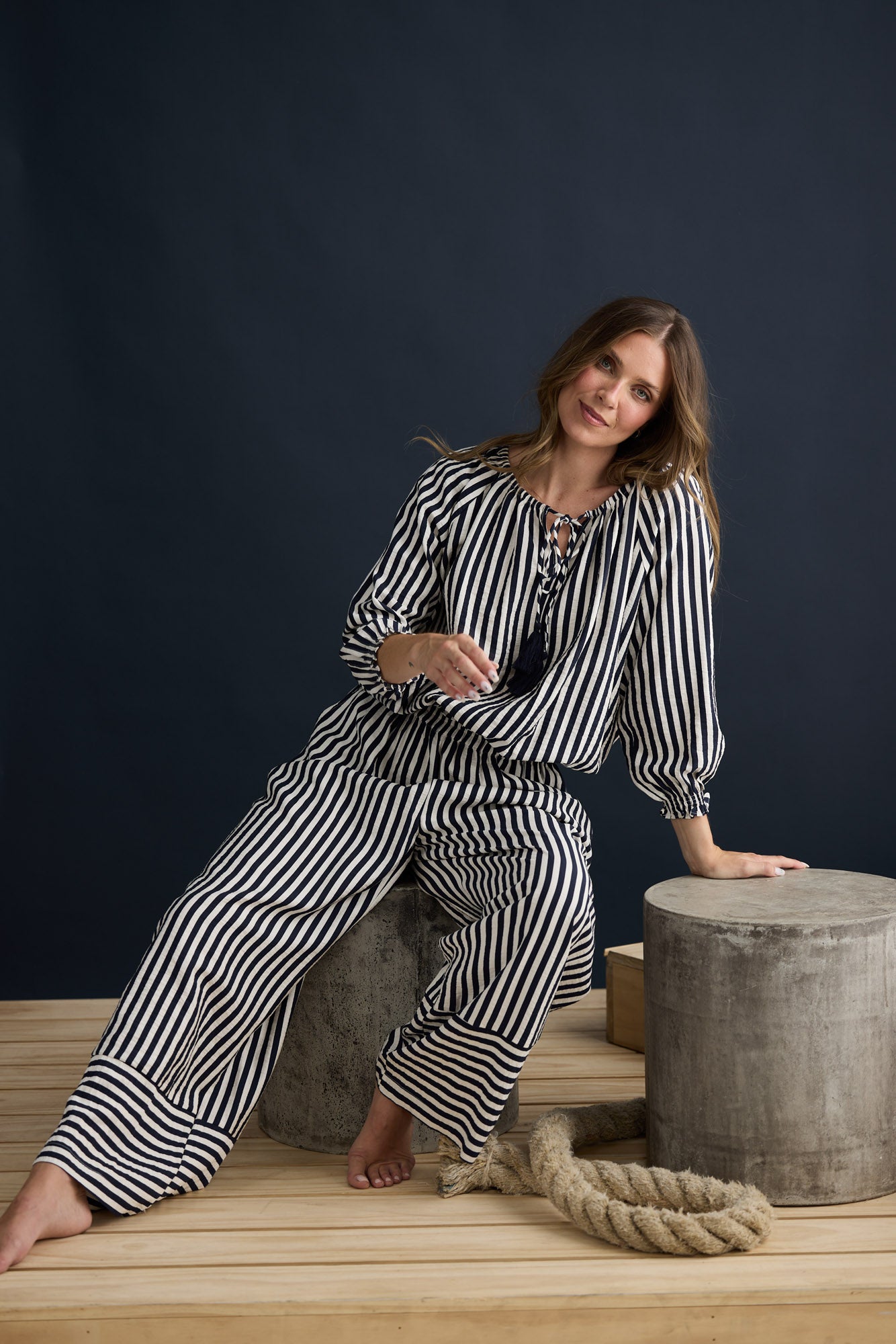 Model wearing Seaside Top Navy and White Stripe with neck ties and shirred cuffs, campaign lifestyle view