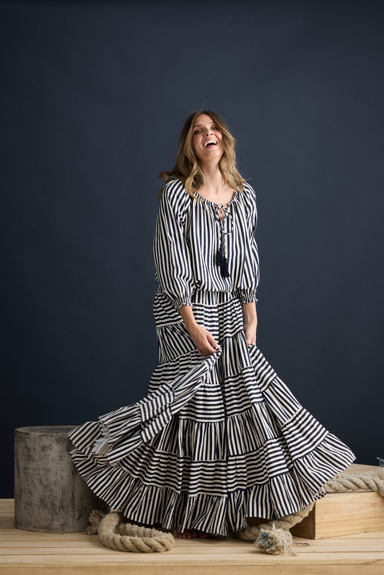 Model wearing Seaside Top Navy and White Stripe with neck ties and shirred cuffs, campaign lifestyle view