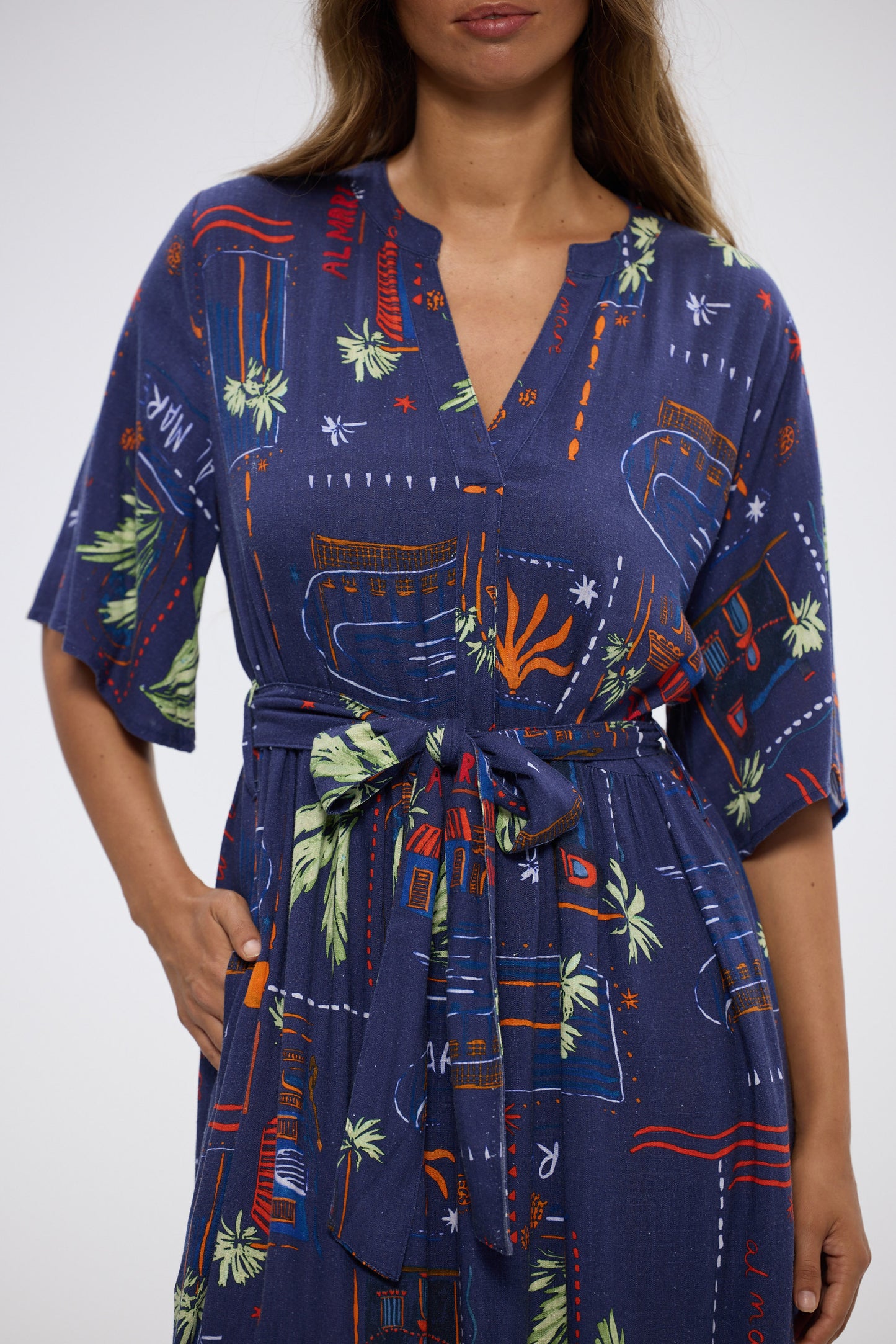 Woman wearing a blue dress with colorful abstract patterns on a white background