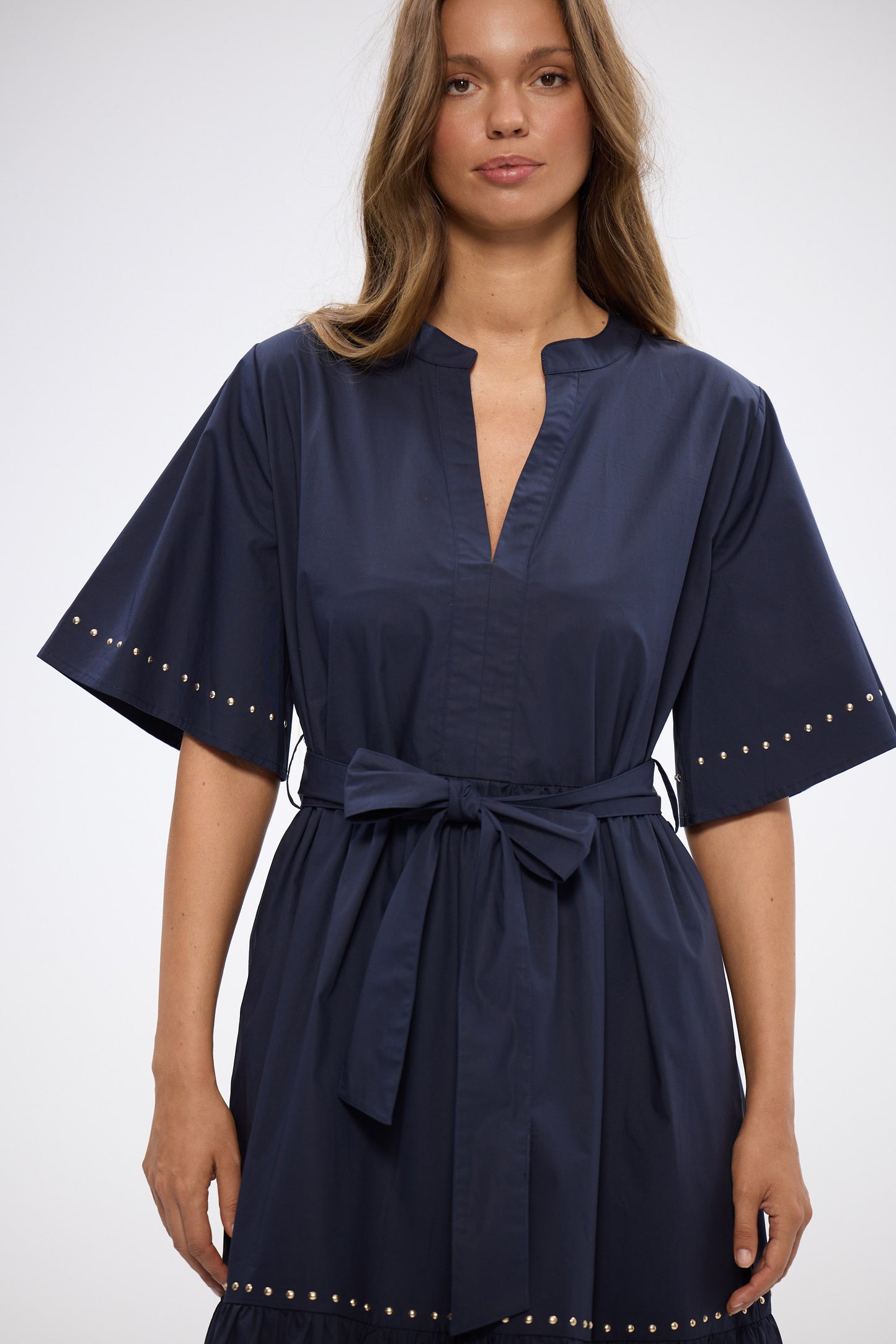 Navy blue dress with a belt worn by a model on a white background
