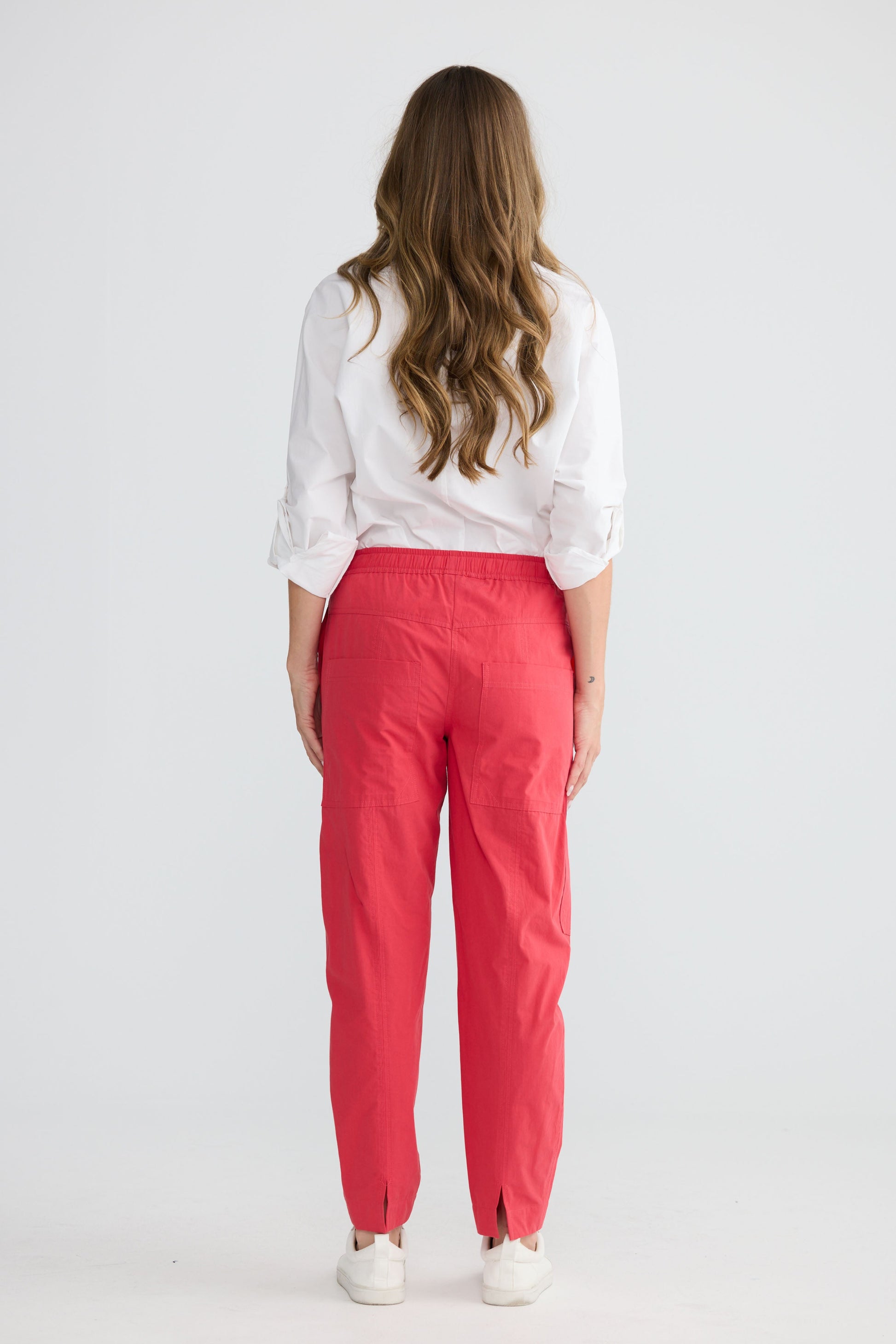 Model wearing Reva Cargo Pant Red with drawstring waist and cargo pockets, full-length view on white background