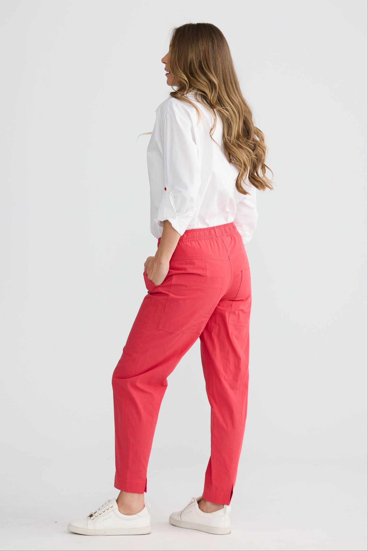 Model wearing Reva Cargo Pant Red with drawstring waist and cargo pockets, detail view on white background