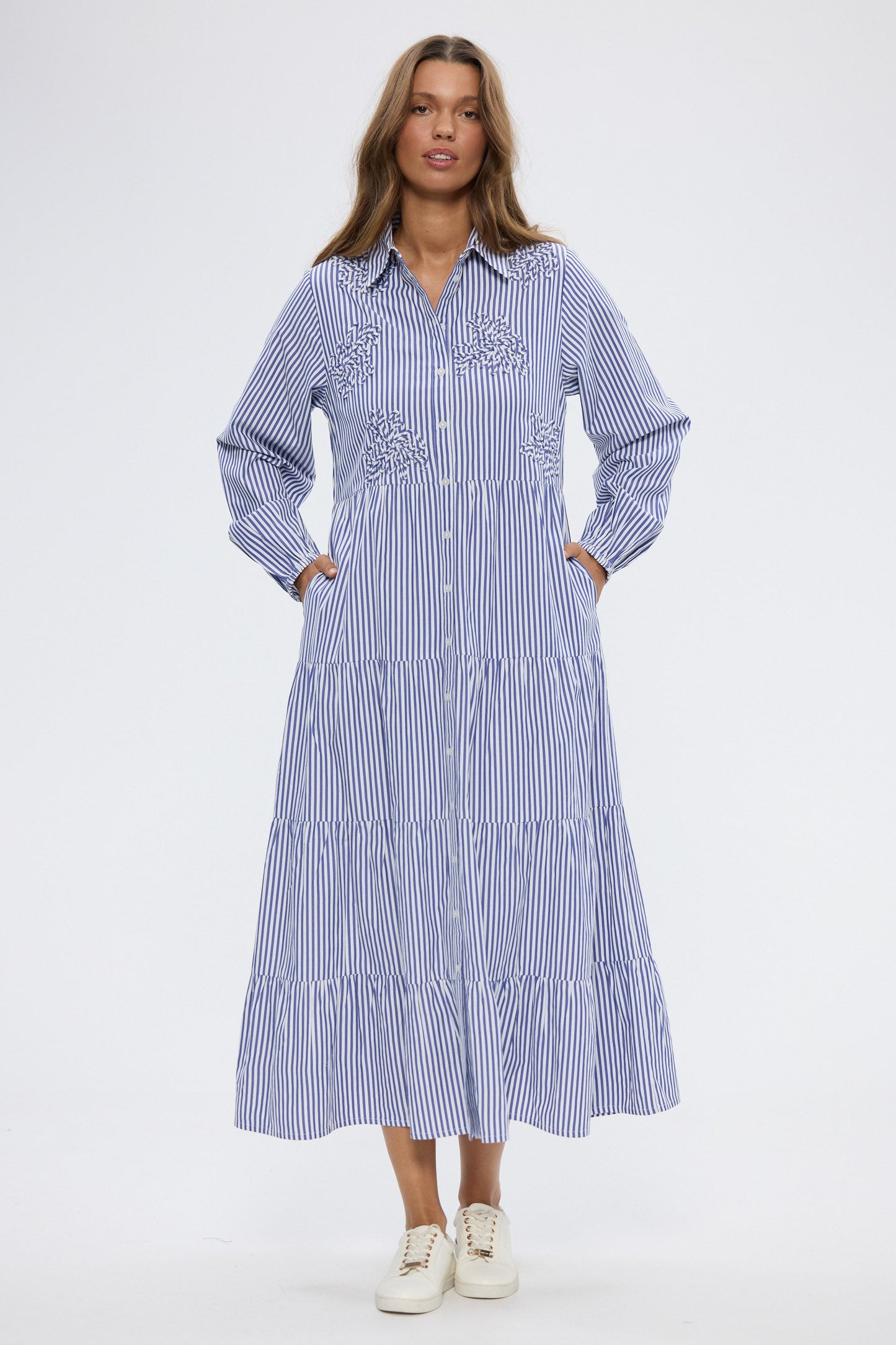 Woman wearing a blue and white striped dress on a white background