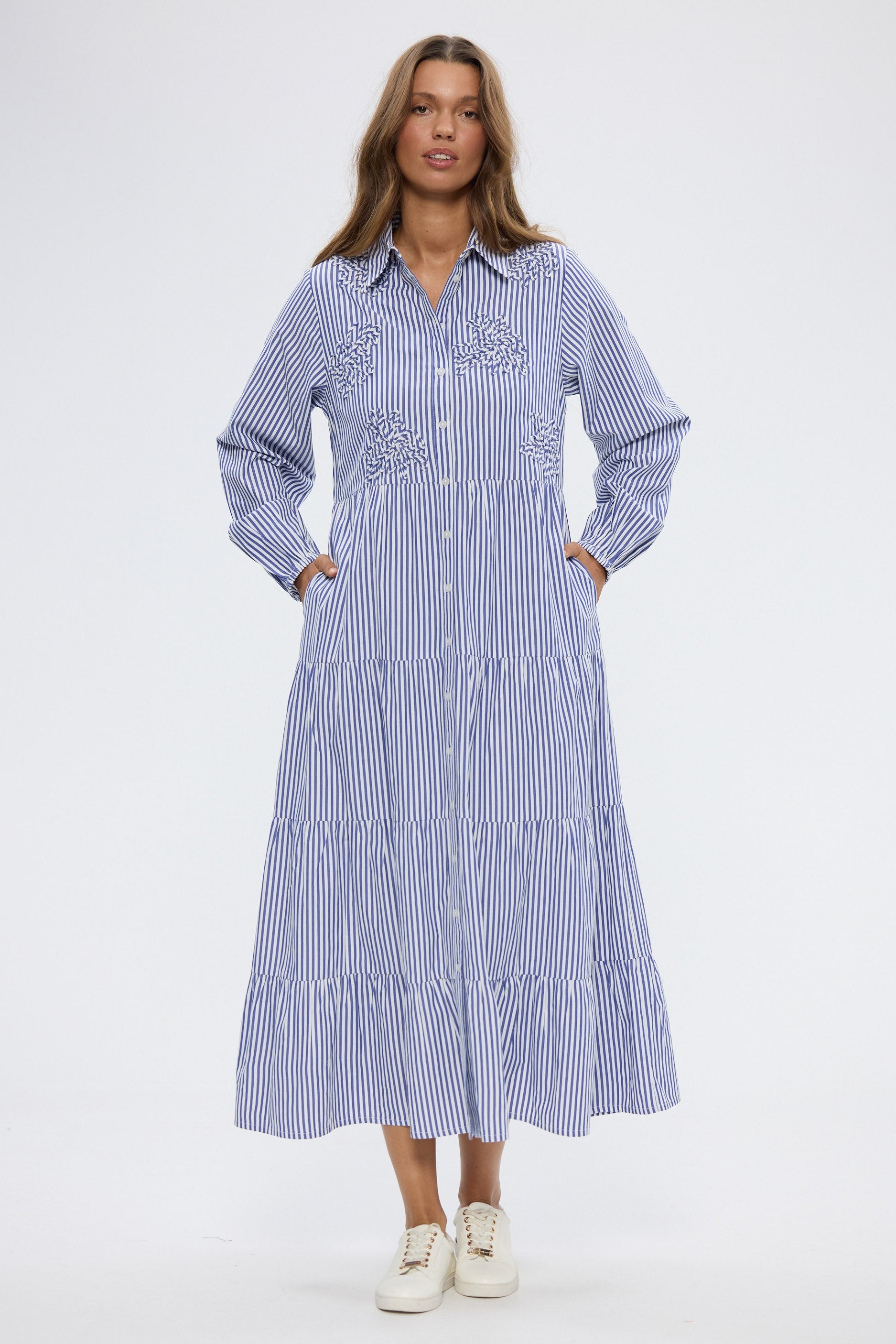 Woman wearing a blue and white striped dress on a white background