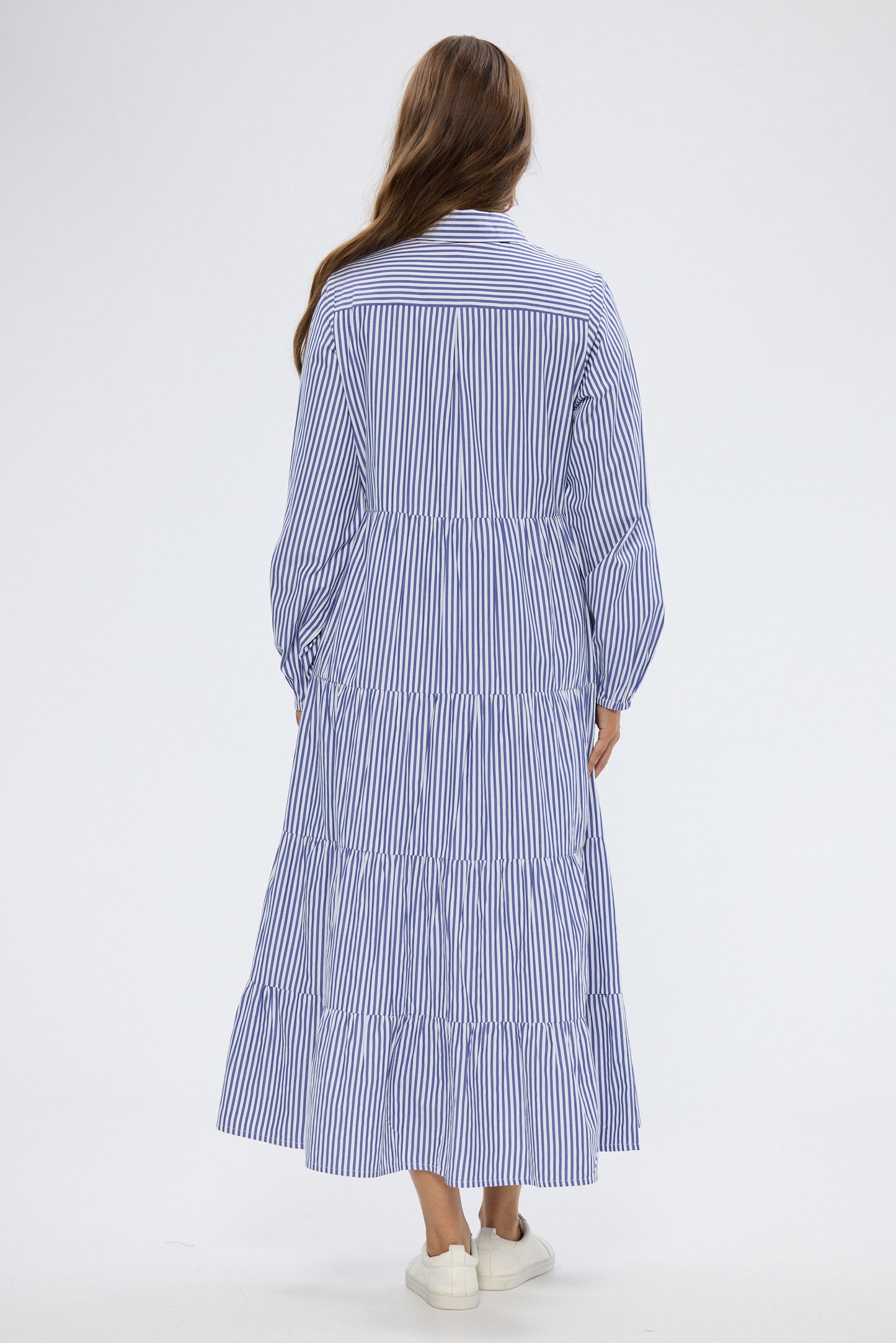 Woman wearing a blue and white striped dress on a white background