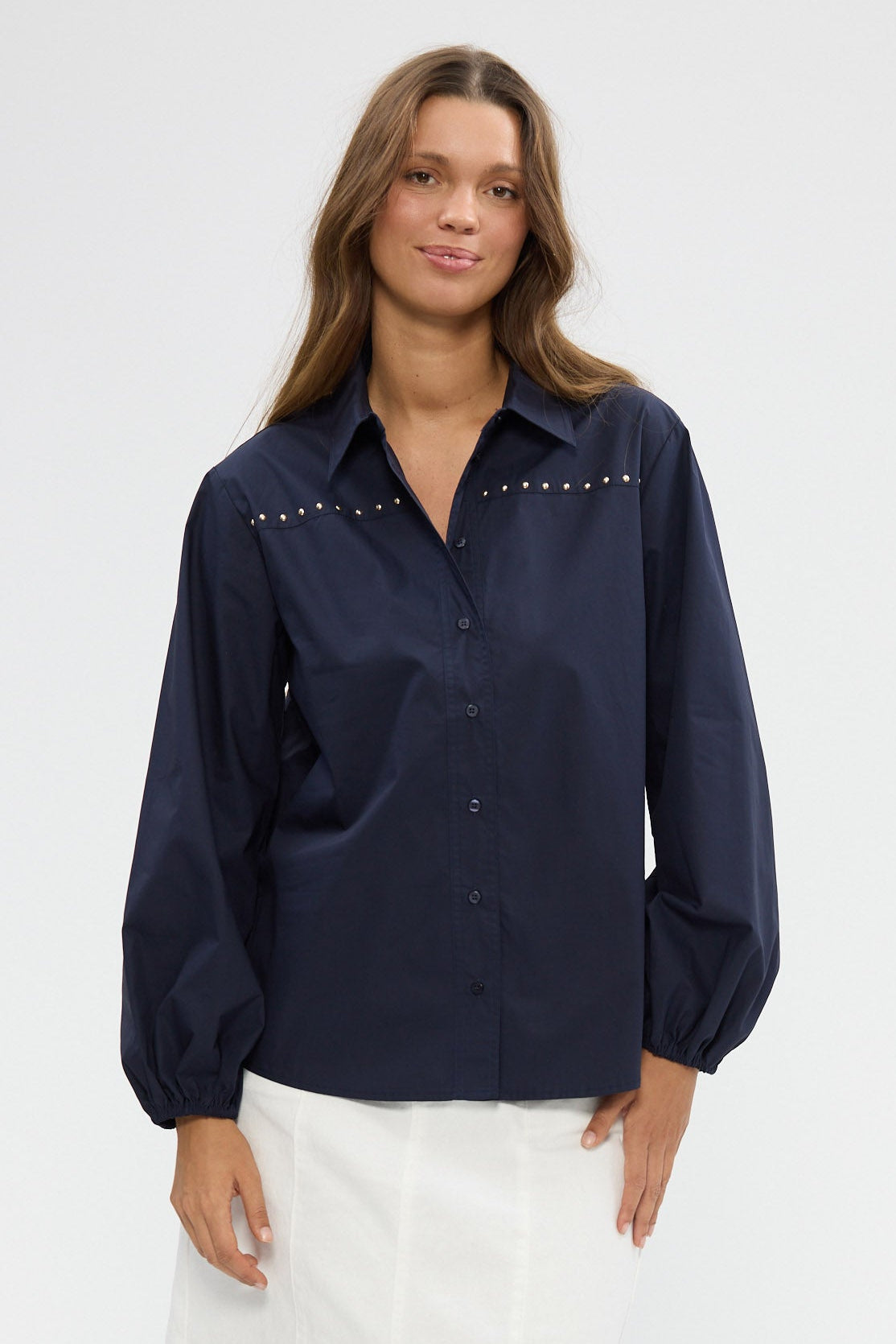 Woman wearing a navy blouse on a white background