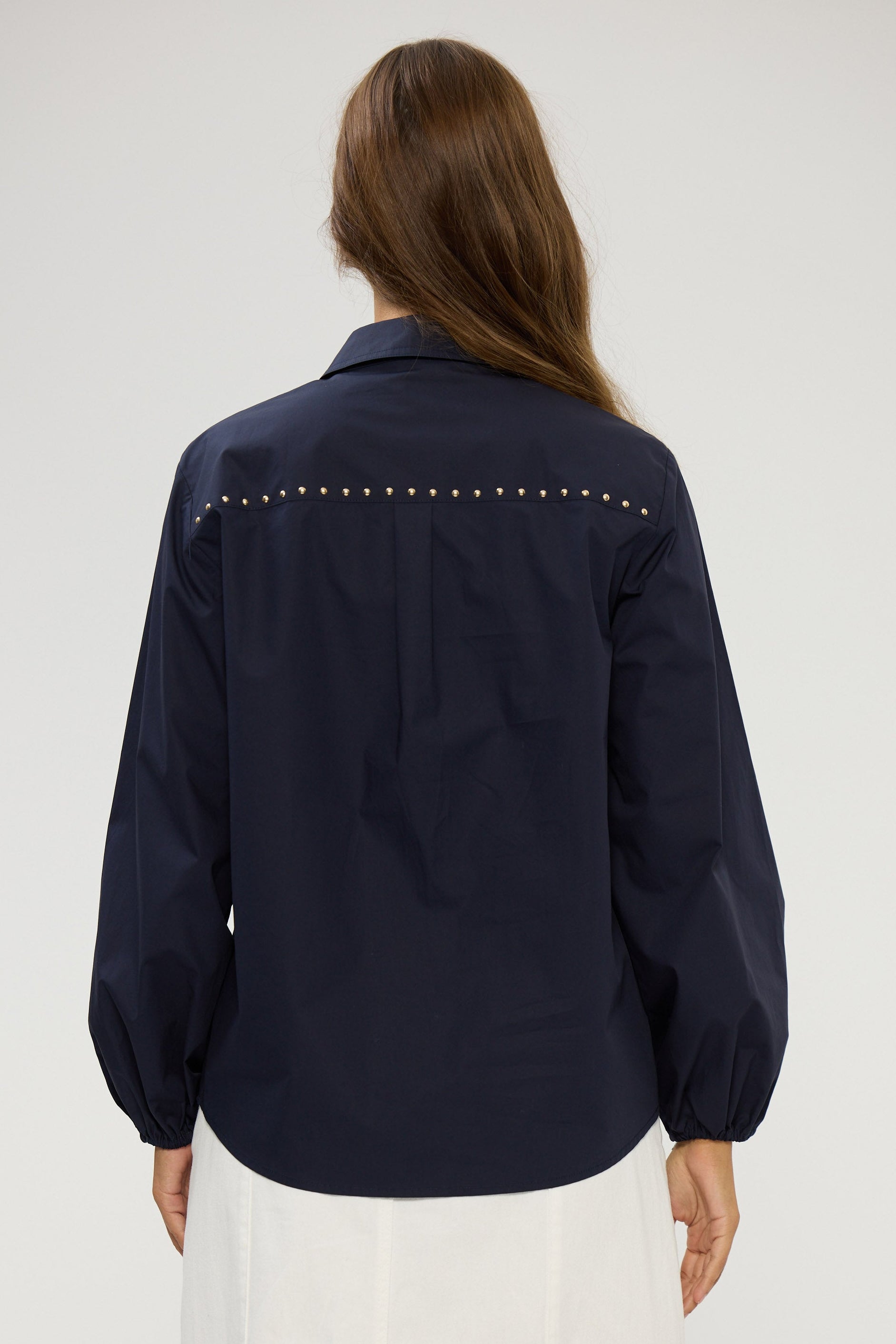Navy blue shirt with studded details on a white background
