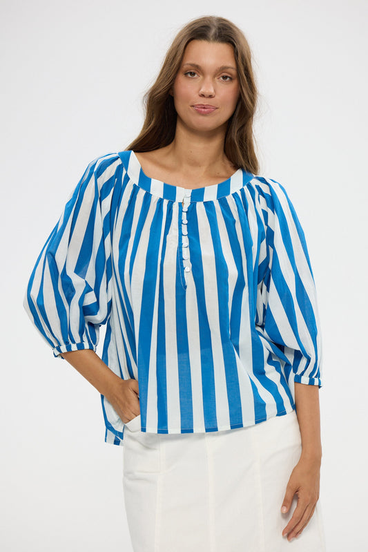 Woman wearing a blue and white striped blouse against a white background