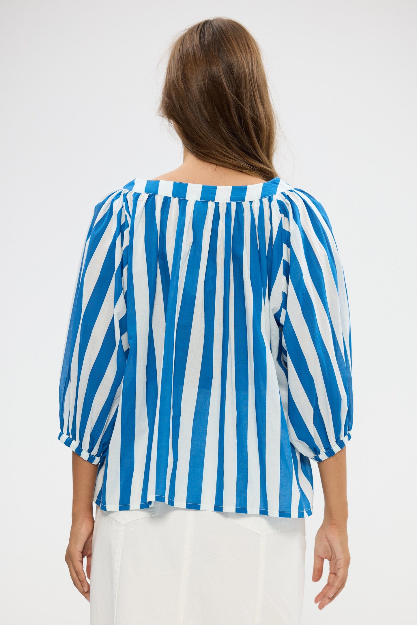Woman wearing a blue and white striped blouse on a white background