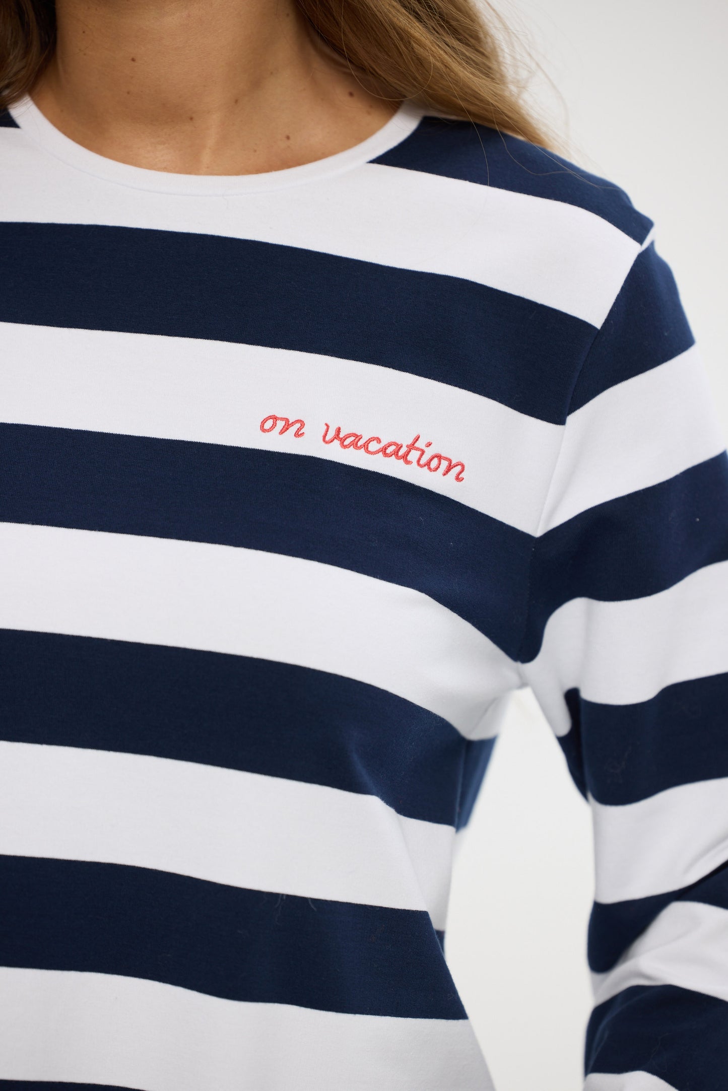 Navy and white striped shirt with 'on vacation' text on a plain background