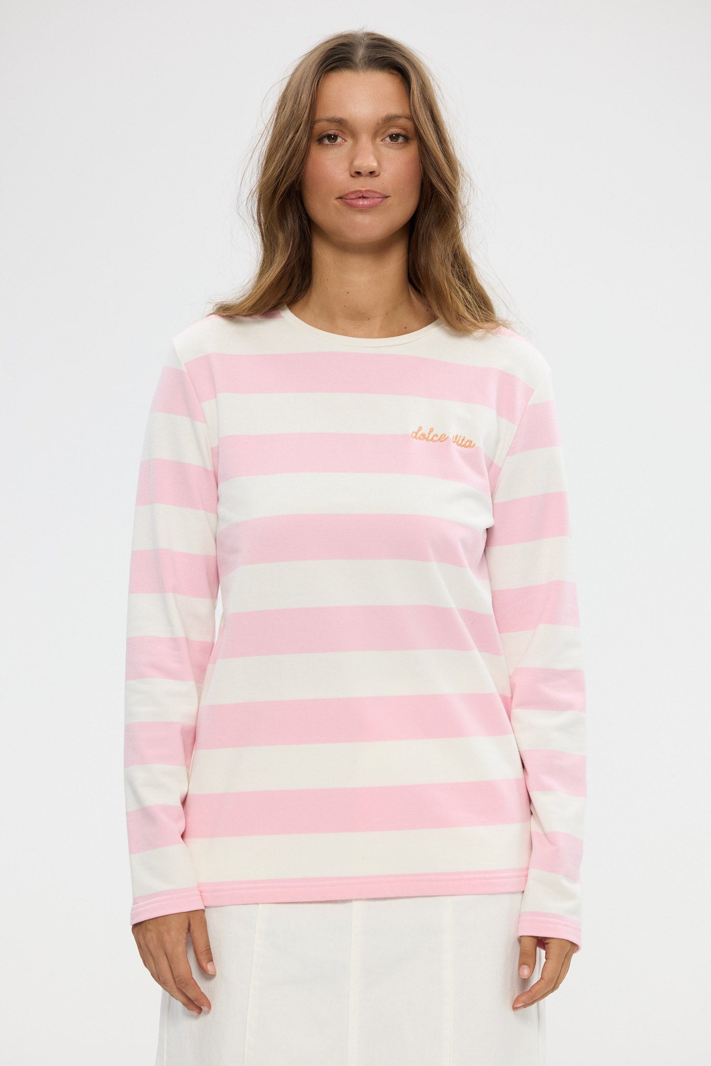 Woman wearing a pink and white striped sweater on a white background