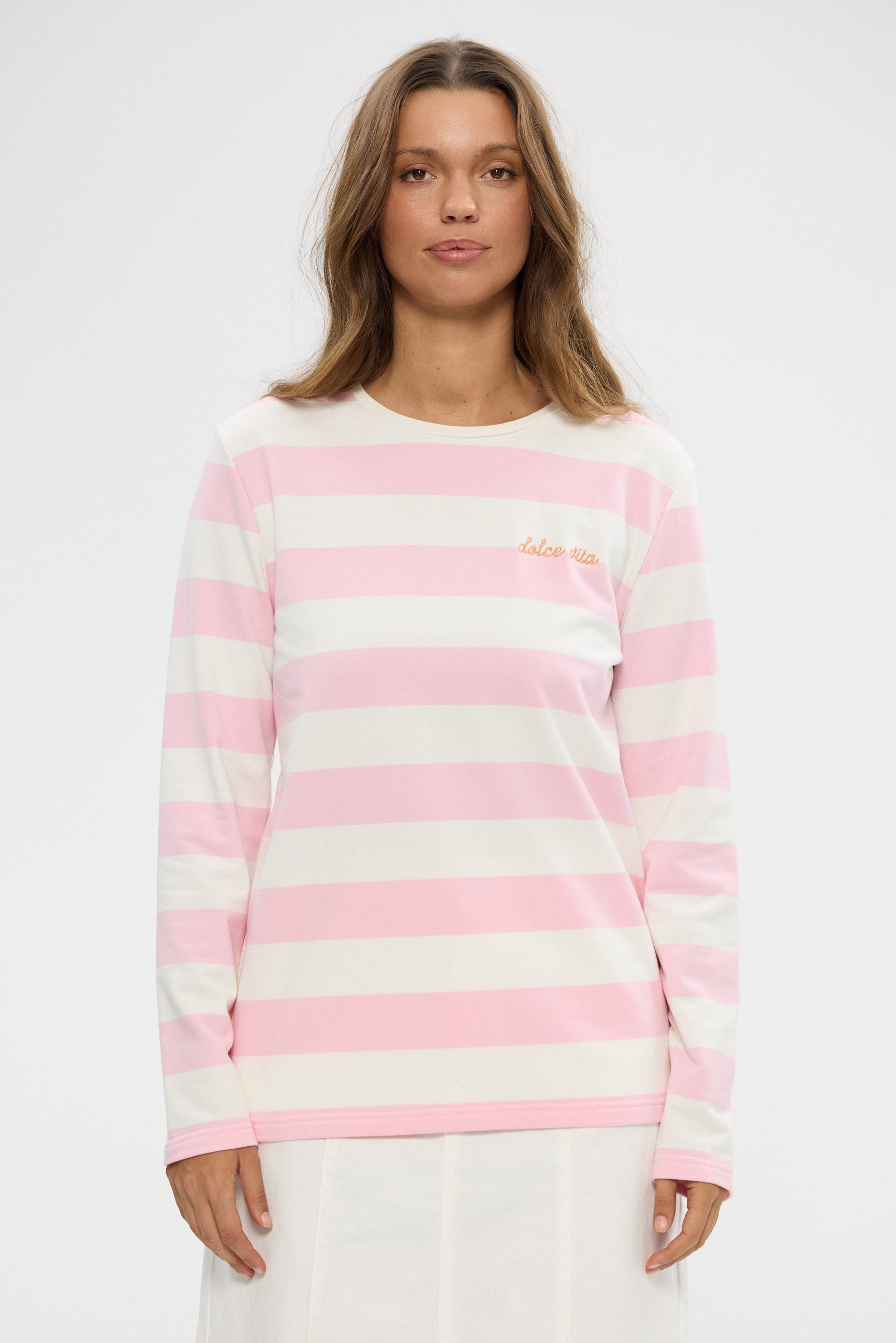 Woman wearing a pink and white striped sweater on a white background
