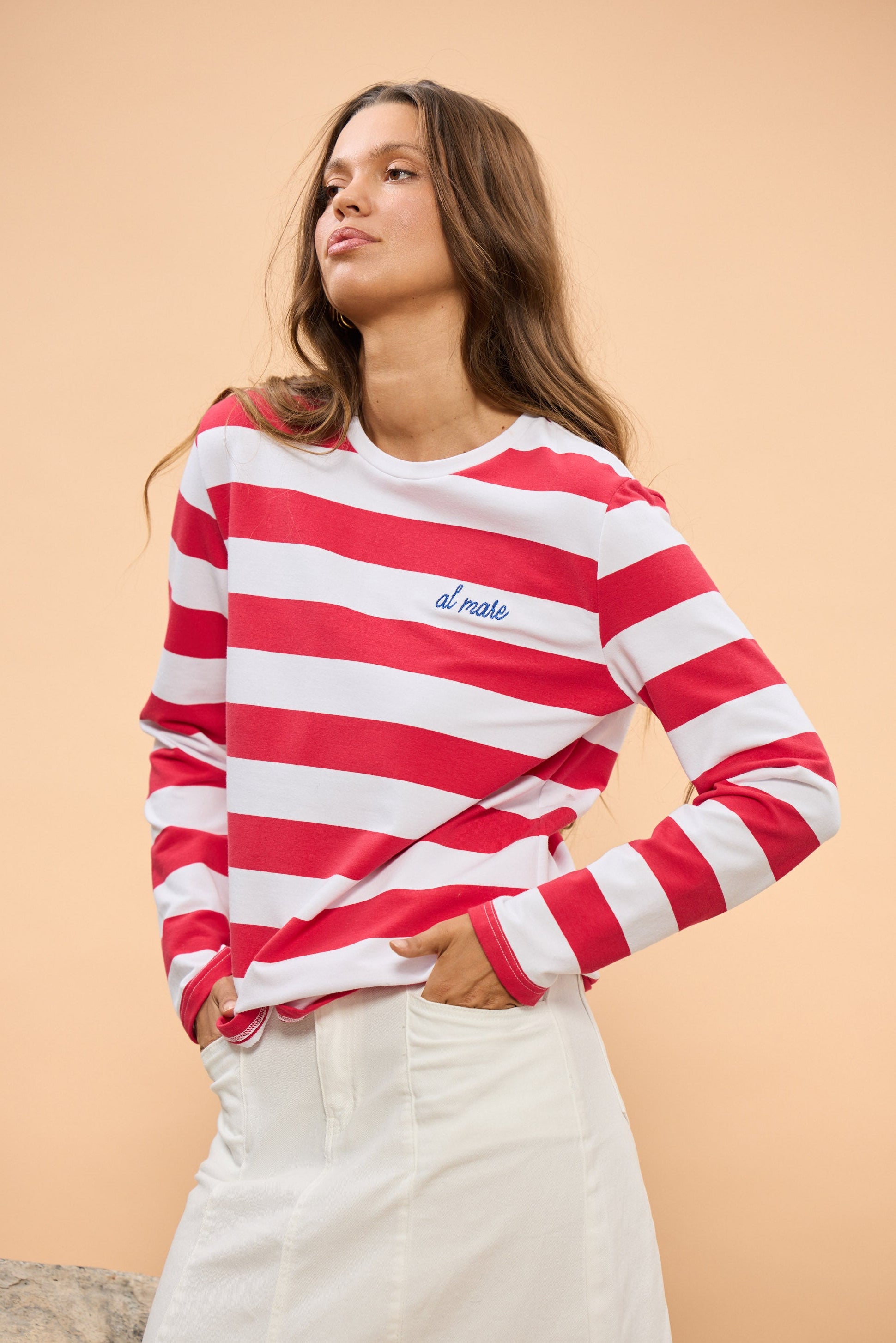 Woman wearing a red and white striped shirt with 'el mare' text on a beige background