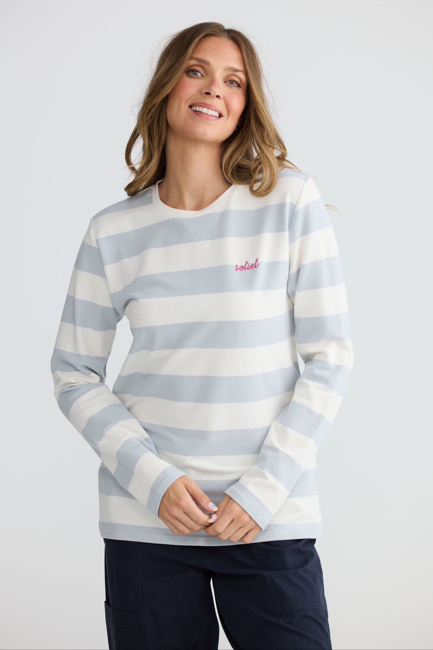 Model wearing Roam Tee Light Blue Stripe with long sleeves and striped finish, detail view on white background