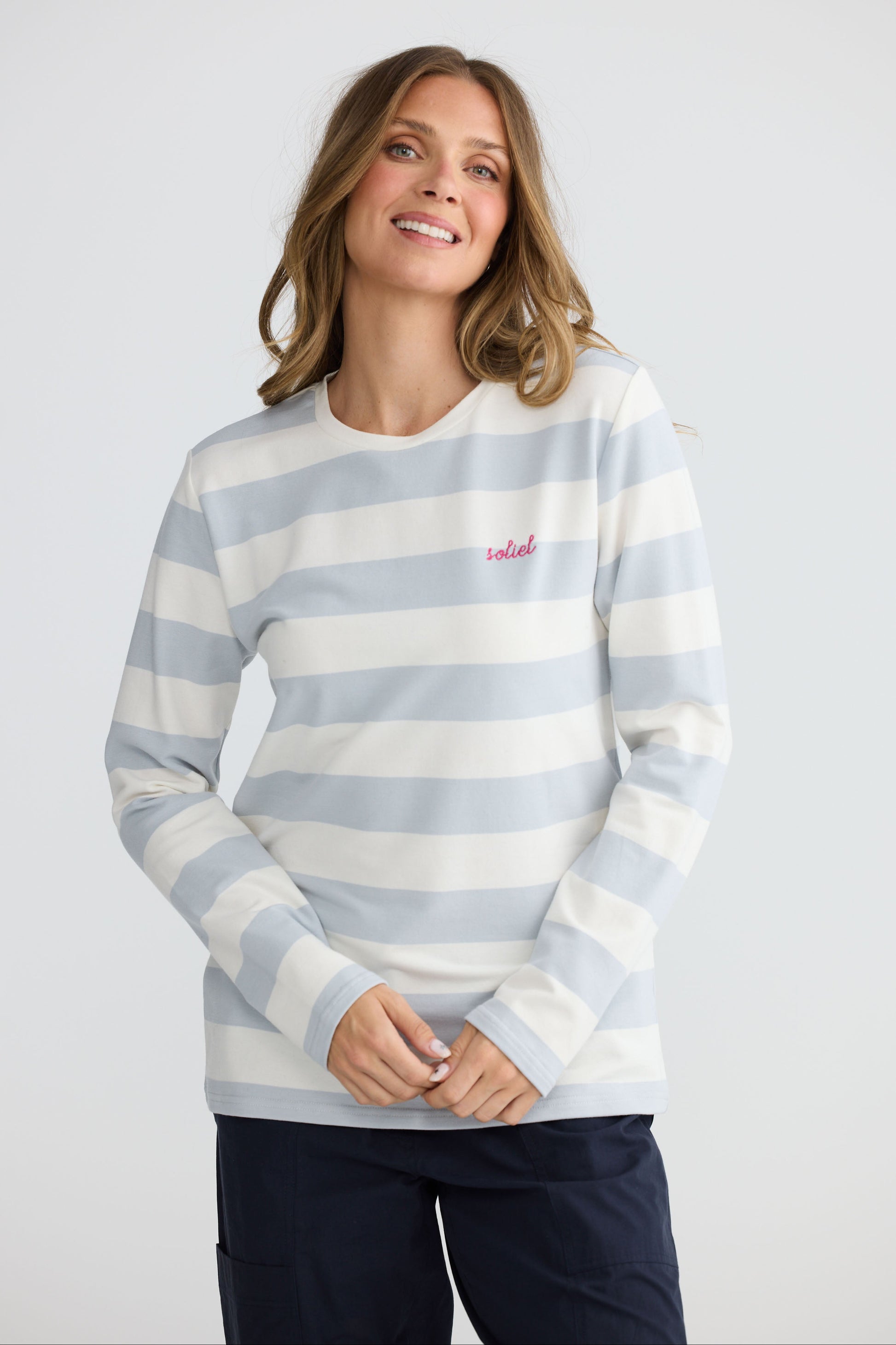 Model wearing Roam Tee Light Blue Stripe with long sleeves and striped finish, detail view on white background