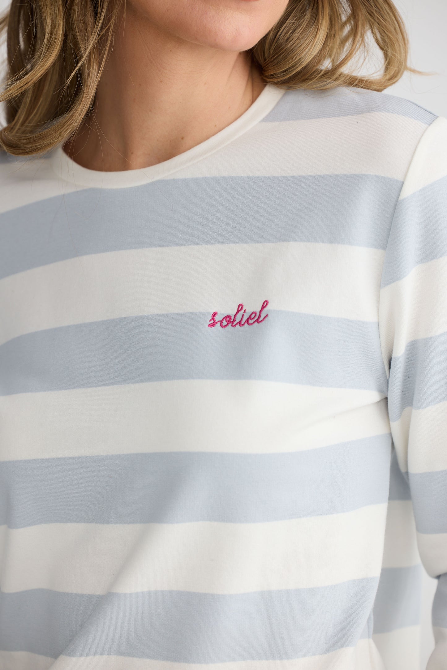 Model wearing Roam Tee Light Blue Stripe with long sleeves and striped finish, alternate view on white background
