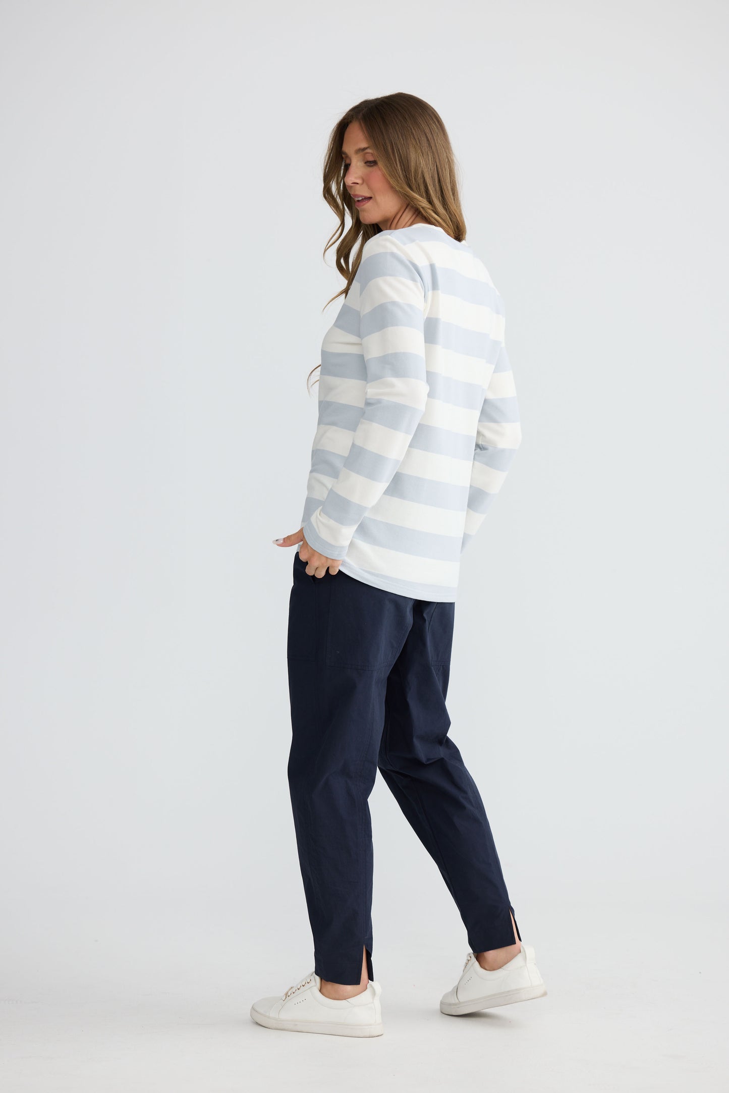Model wearing Roam Tee Light Blue Stripe with long sleeves and striped finish, back view on white background